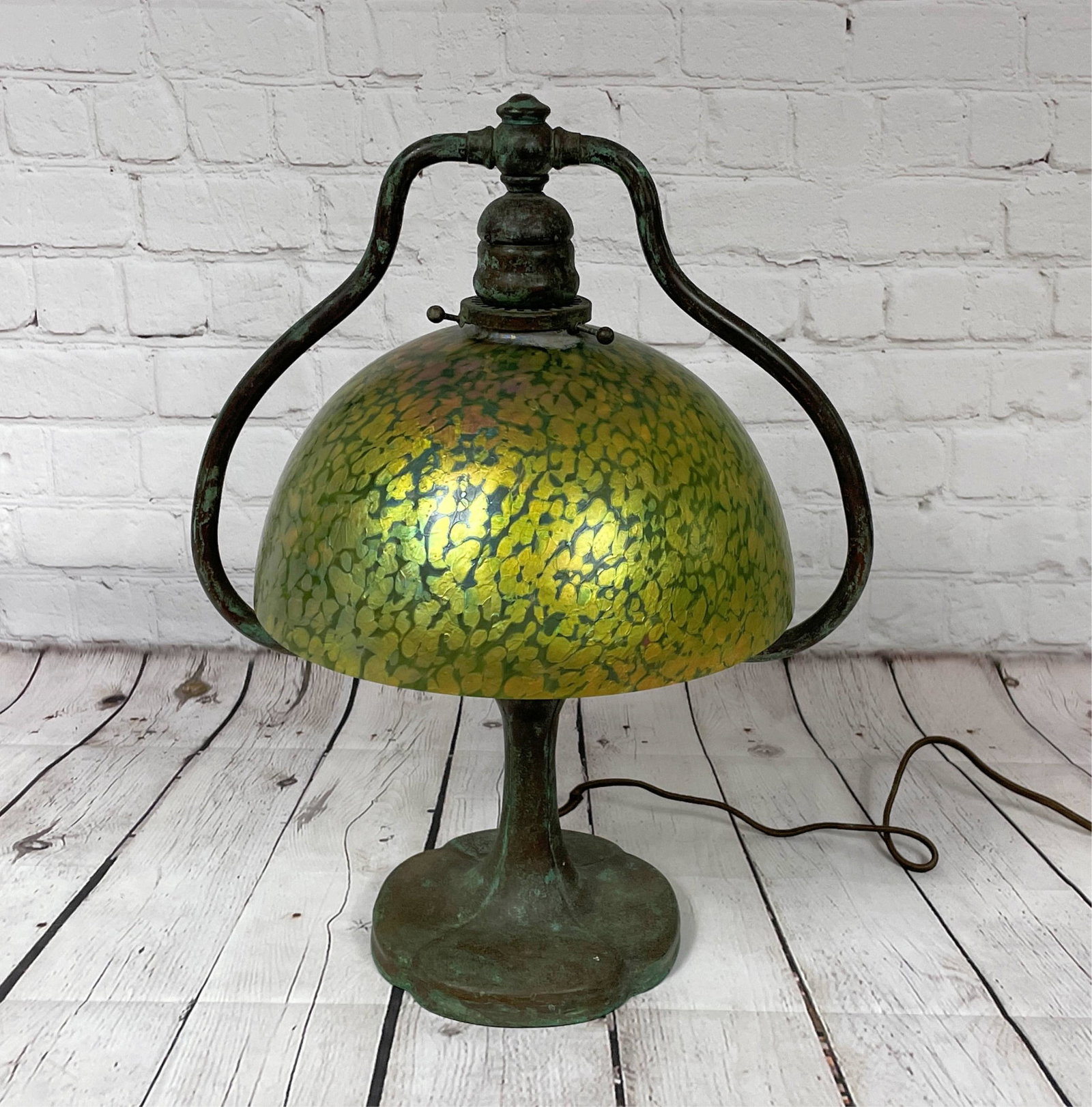 Antique Handel Harp Table Lamp: Antique Handel Harp Table Lamp . A bronze base with "oil spot" glass shade. The socket and wiring appear original. Unsigned. Good condition with typical chips at top opening. The base measures 16-3/4"