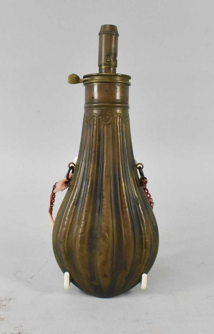 Orig Civil War Era Am Flask Cap Co Brass Powder Flask: Original Civil War Era Brass powder flask, with ribbons attached, there are a few minor dents from use. The top and thumb lever move easily. Marked on the top Am. Flask and Cap Co. Dimensions 8 1/2" t