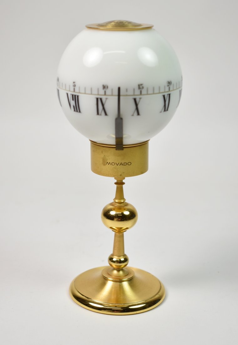 Movado Desk Clock Tempus Fugit: Movado Desk Clock. Marked "Movado Factories 8-Days - Swiss", engraved with 14-1947. 7" tall x 3" diameter, not working. Brass base and top marked Tempus Fugit. Balls rotate.