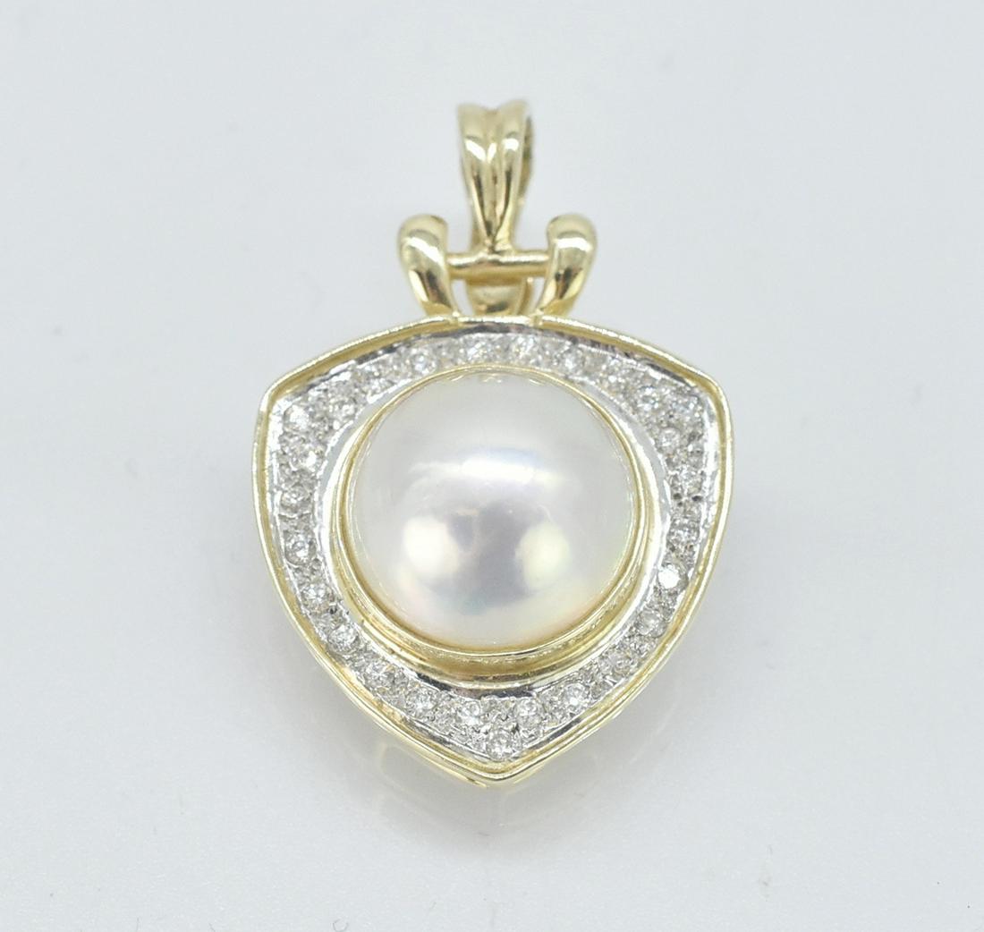14K Gold, Mabe Pearl, and .5 ct Diamond Pendant: 14K yellow gold pendant with a central Mabe pearl surrounded by .5 cttw diamonds. Pearl is approximately 13mm diameter. Triangular shaped pendant. 1 1/4" long x 3/4" wide. Stamped 14K 5.6 grams