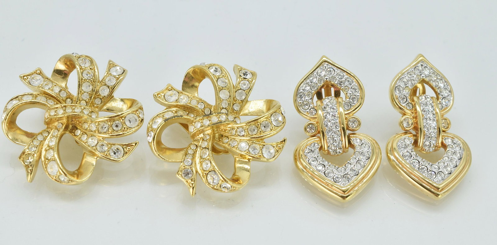 Kenneth J Lane and Swarovski Pierced Earrings: Kenneth J Lane and Swarovski pierced earrings. KJL bow earrings set with glass stones 1 3/8" diameter. Swarovski double heart earrings connect with a bar and encrusted with Swarovski crystals. 1 5/8" 