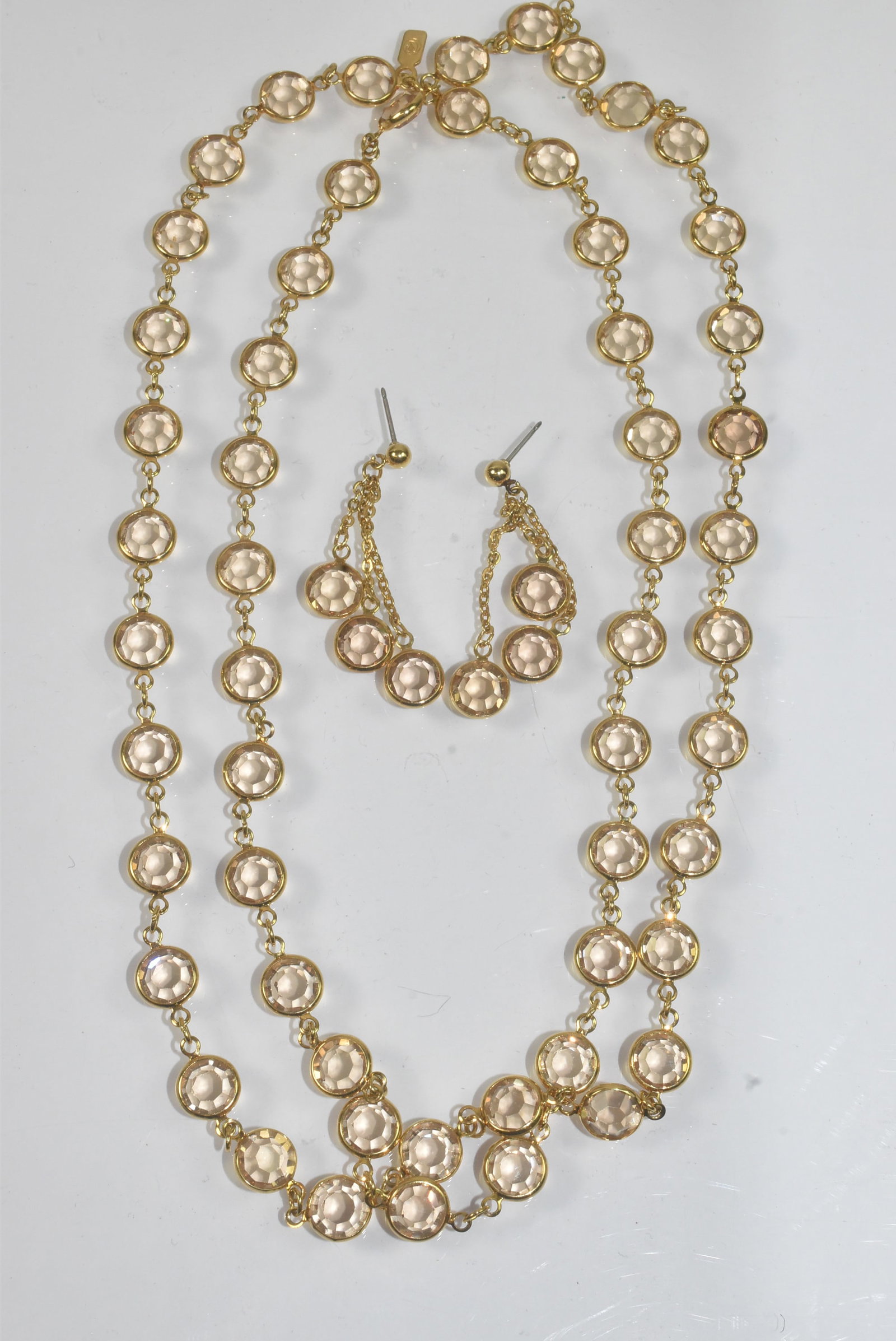 Swarovski Clear bezel Necklace, Earrings: Swarovski clear bezel necklace and earrings in a gold tone. Pierced earrings with triple dangle. Necklace measures 36" long.