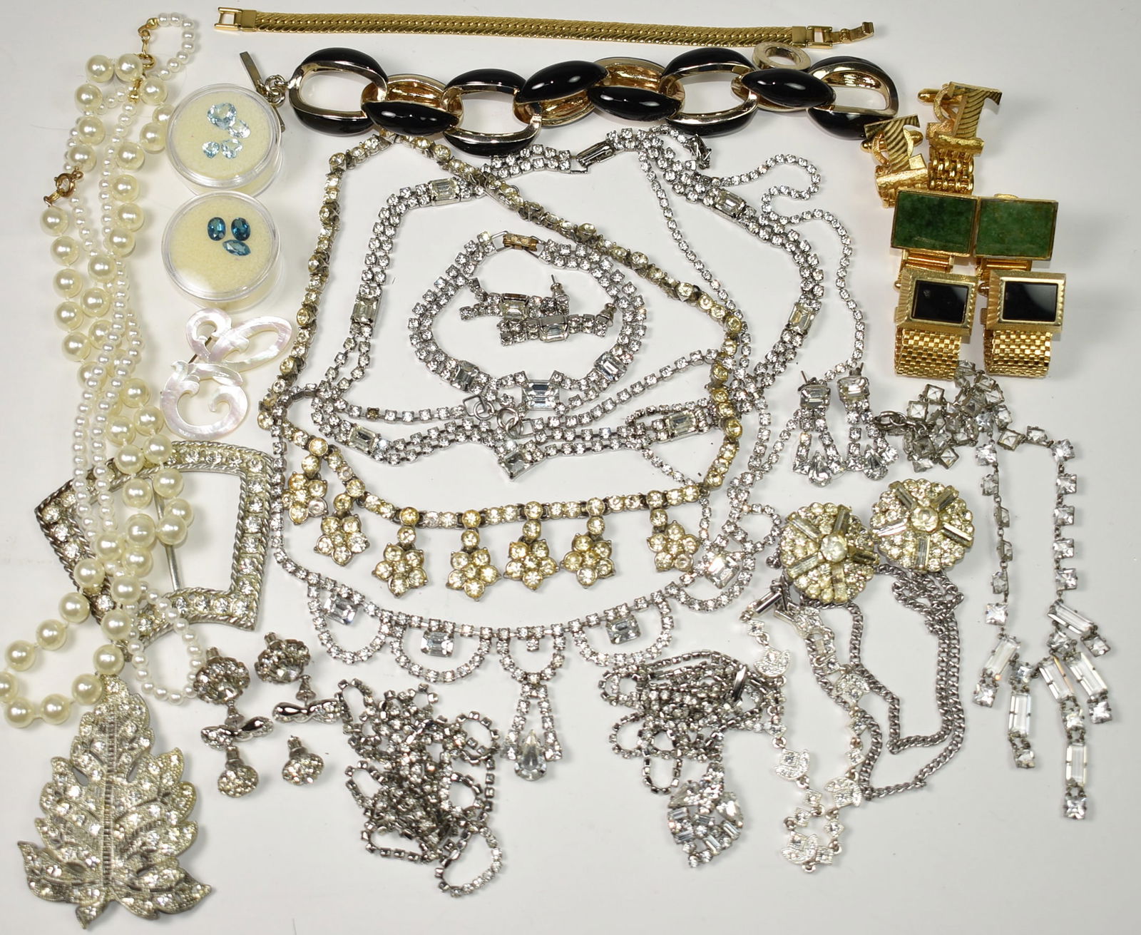 Rhinestone Jewelry Lot: 3 pairs of cufflinks, loose stones, dark blue Neptune color, medium blue London blue color, light blue aquamarine, 9 necklaces 14" - 29", 4 bracelets, 5 pairs of pierced earrings, sweater pin, buckle,