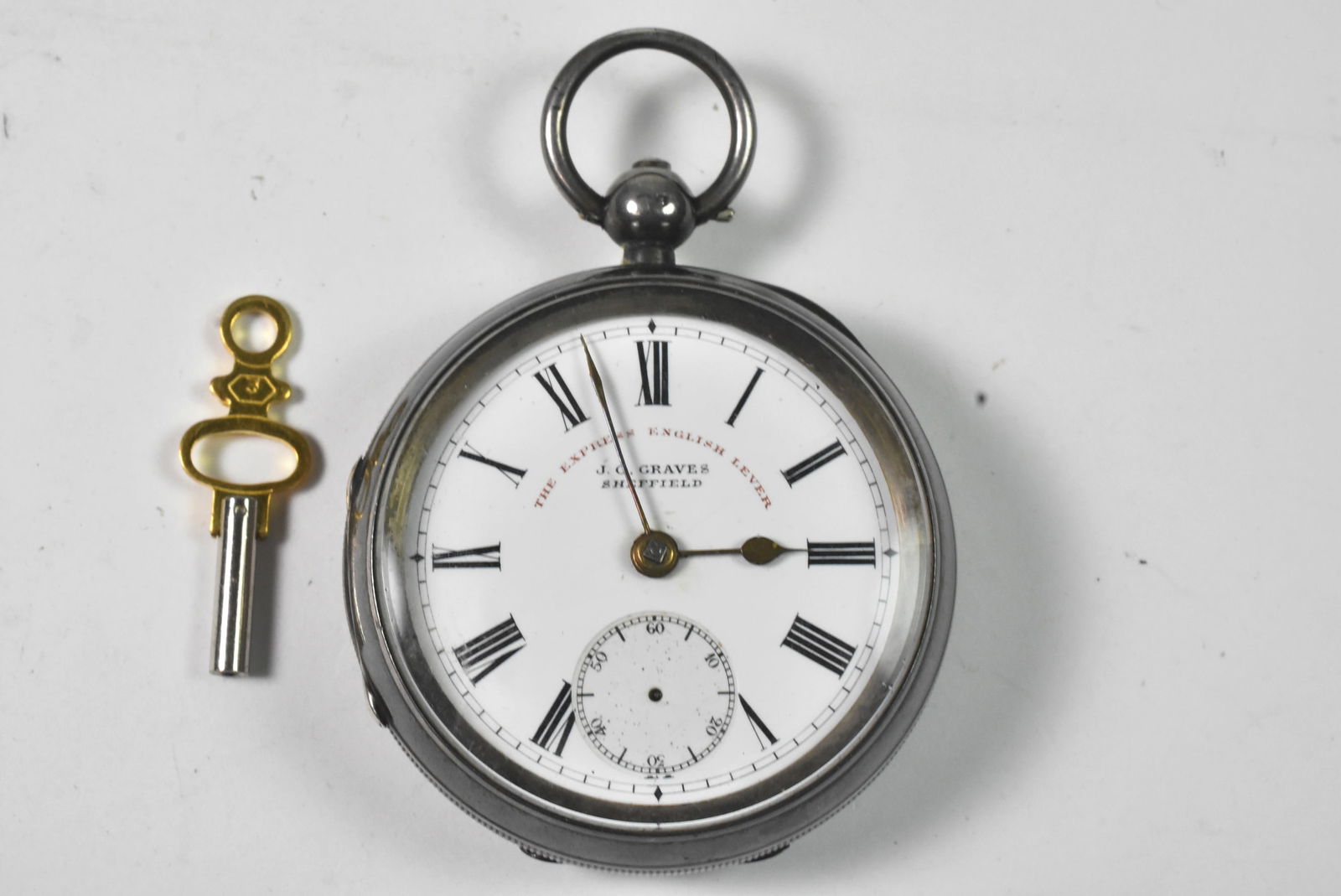 English Sterling Silver JG Graves Pocket Watch: English Sterling silver J.G. Graves pocket watch. 38mm. Case hallmarked and stamped CHE. Porcelain dial missing second hand. Running, some dents. Key wind includes key. 128 grams.