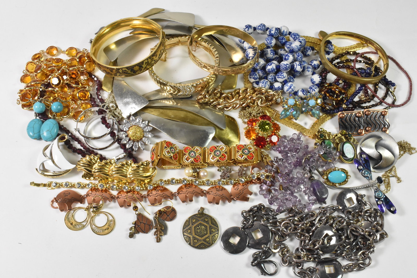 Lot of Mixed Metal Jewelry, Dragonfly, Swarovski Style: This lot of mixed metal jewelry contains gold toned bracelets, a white and blue beaded necklace, 23" and a purple crystal necklace. There is a large mixed metal necklace in this lot, 20", that would m