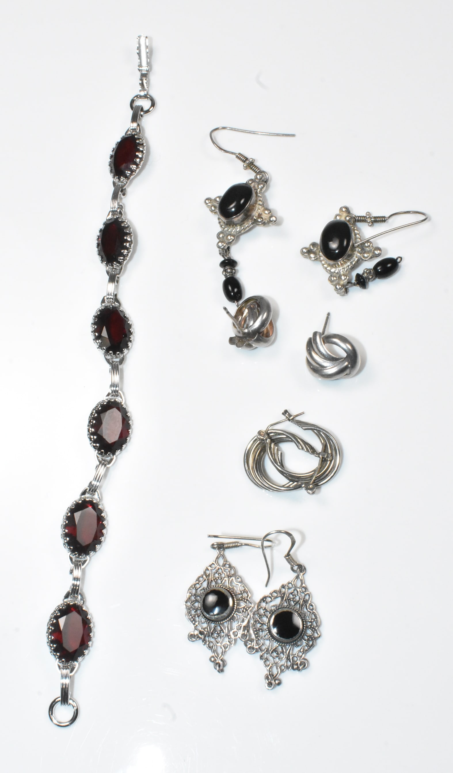 Sterling Earrings and Bracelet Group: 4 pair sterling earrings, longest is 2". 7" bracelet with garnet like stones. 31.7g.