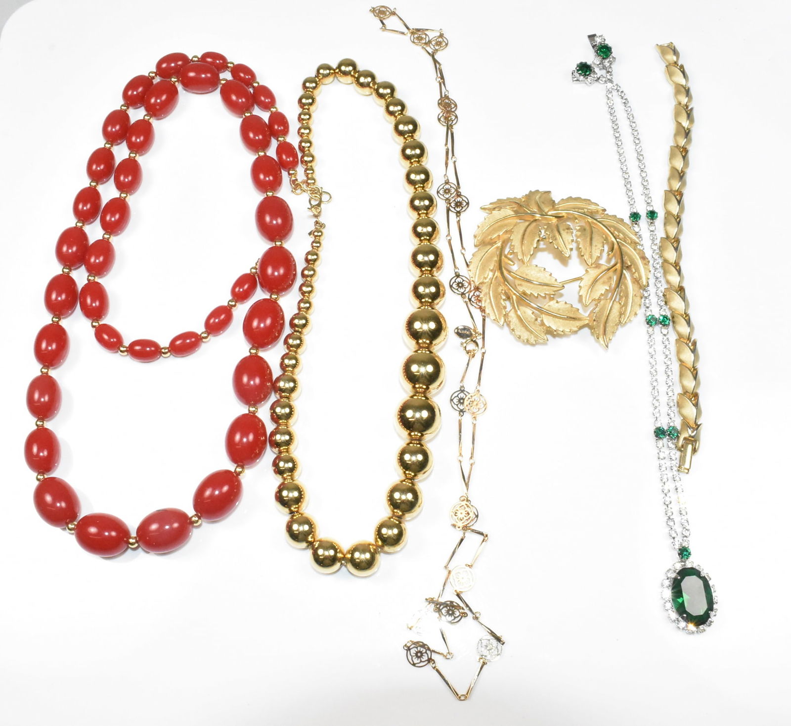 Fashion Jewelry Group with Trifari, Monet, Avon: Group of 6 fashion jewelry pieces including Trifari gold tone leaf pin brooch 2 1/2" wide, Trifari gold tone leaf bracelet 6 1/2", Monet red graduated oval bead necklace, 28", Monet graduated gold