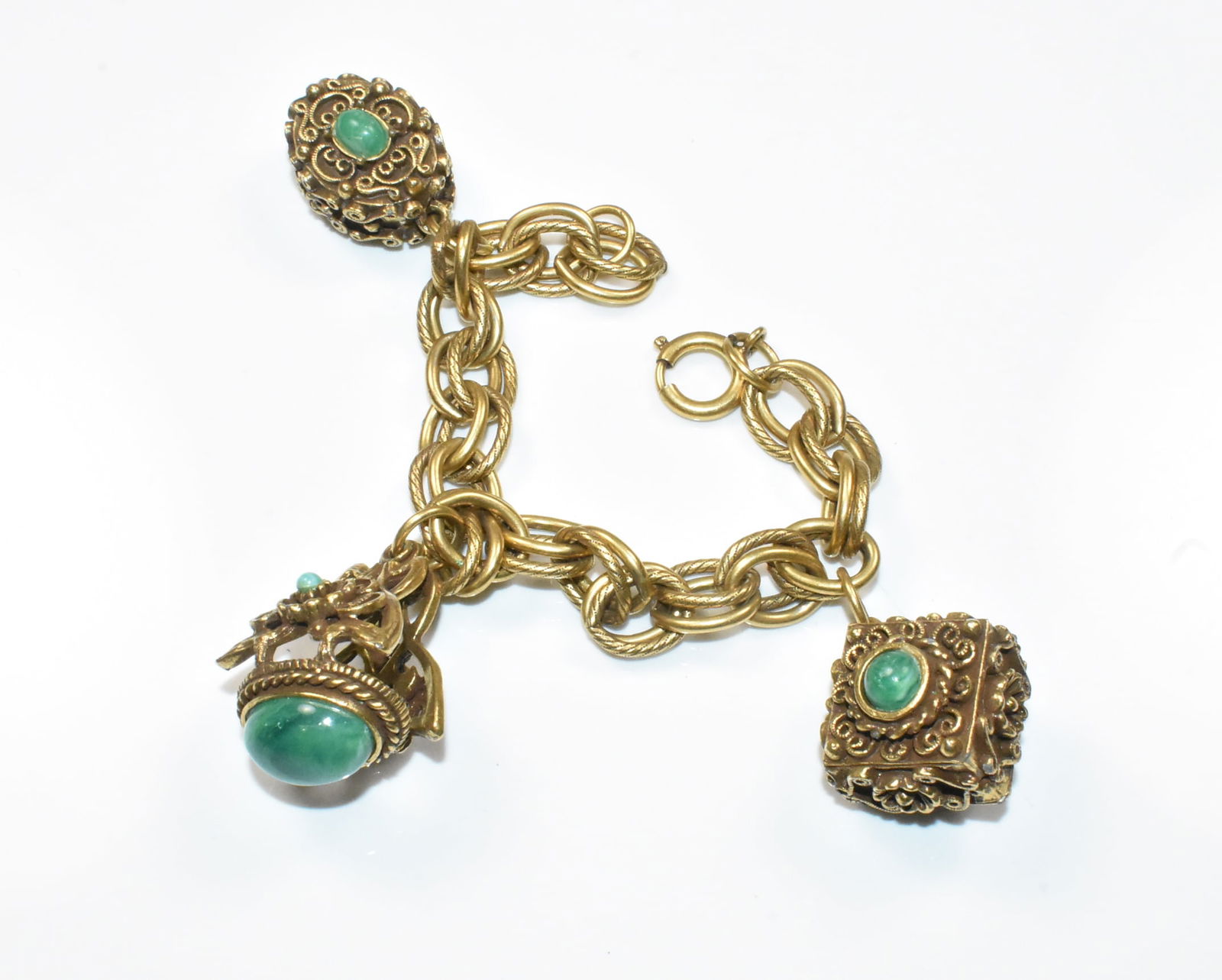 German Gold Filled Charm Bracelet: German GF bracelet with heavy chain and large chunky detailed charms with glass bead accents. Charms measure 1 3/8" long, 1" long, and 3/4" long. Bracelet is 6 1/2". Marked Germany on the clasp.