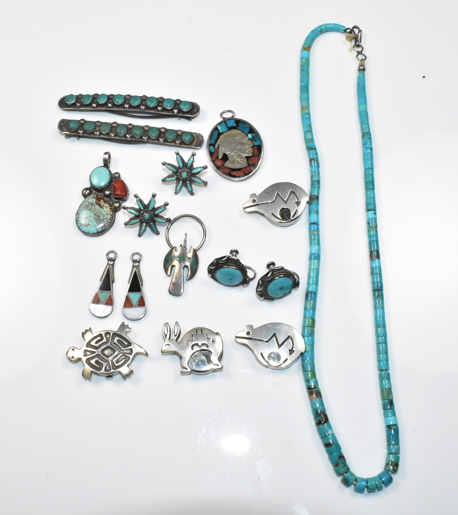 Native American Sterling Jewelry Group: Group of Native American Sterling jewelry includes 4 button covers, a rabbit, a turtle, and 2 bears. Partial sterling mark on one cover; turquoise necklace 17"; pair of hair barrettes 2 1/2"; 5