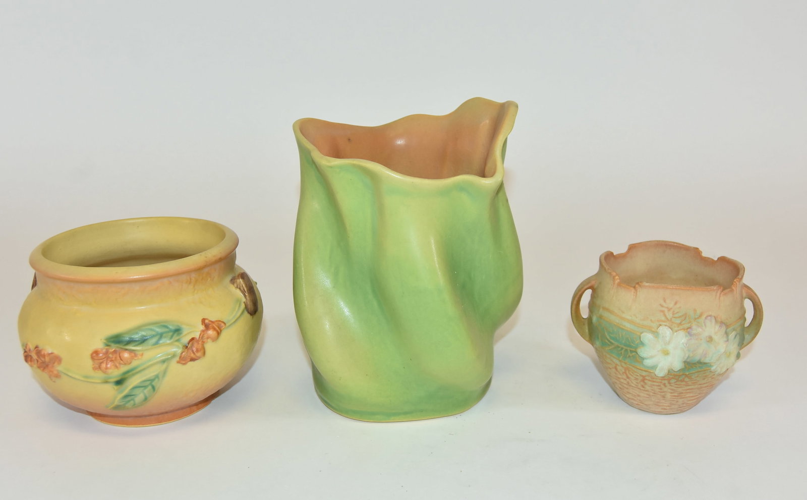3 Pieces Roseville Pottery: Roseville double handle cosmos vase, 3 1/2" tall. Green florane vase with early R mark 81-7. Bittersweet vase factory unglazed, 4" tall, chip on the foot.
