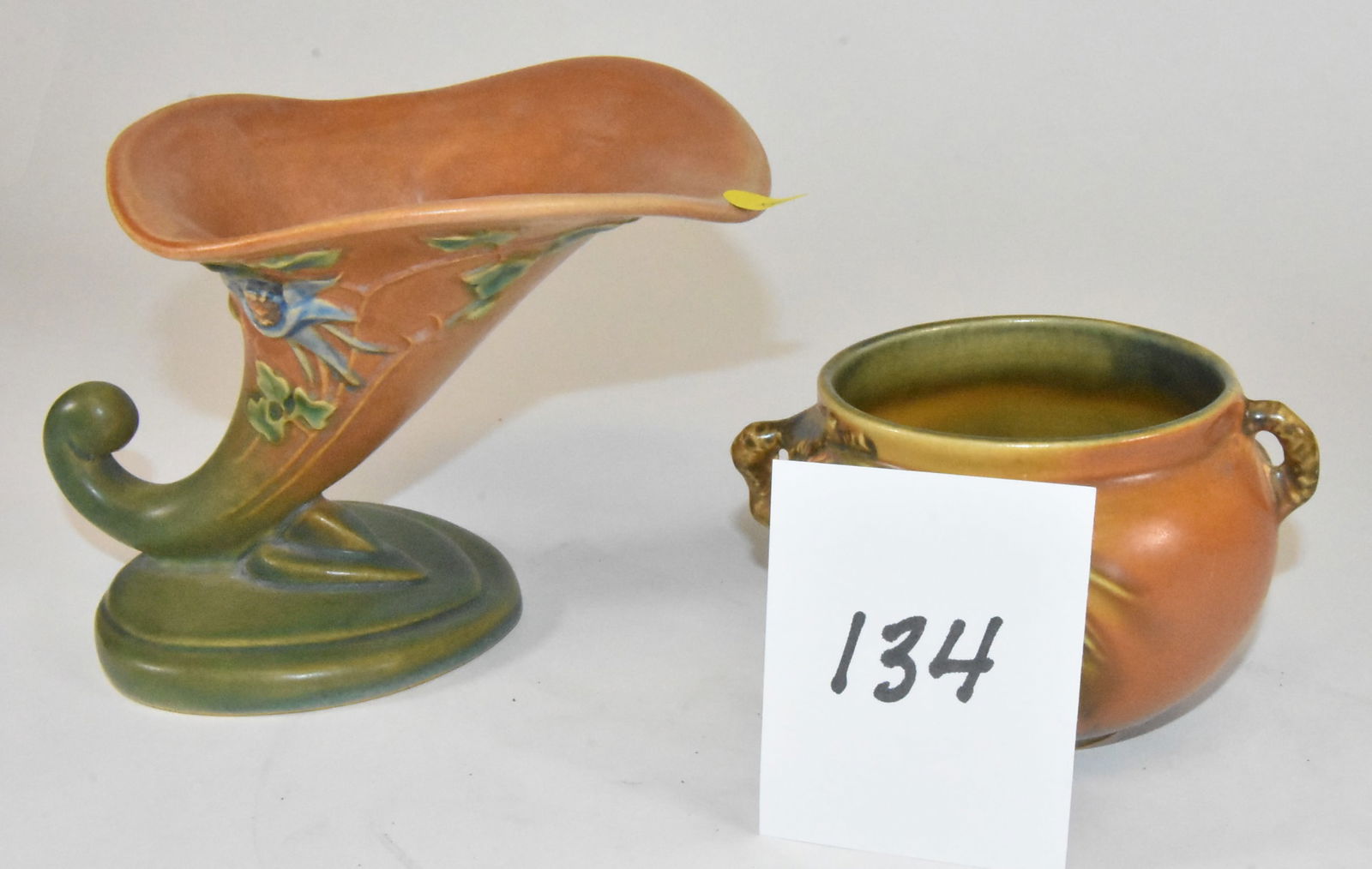 2 Roseville Vases Pincone and Columbine: 2 Roseville vases. Brown double handle pinecone, 3 1/4" tall. Cornucopia form vase with columbine, 5" tall. No damage.