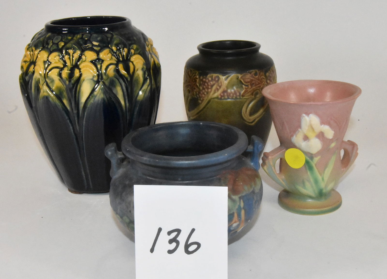 4 vases Including Roseville and Unidentified: Group of 4 vases. Roseville Rosecraft arts and crafts vase with berries and leaves, 5" tall. Roseville double handle pink vase with iris flower, 4 1/2" tall. Blue bowl with fuchsia, 3 1/2" tall,