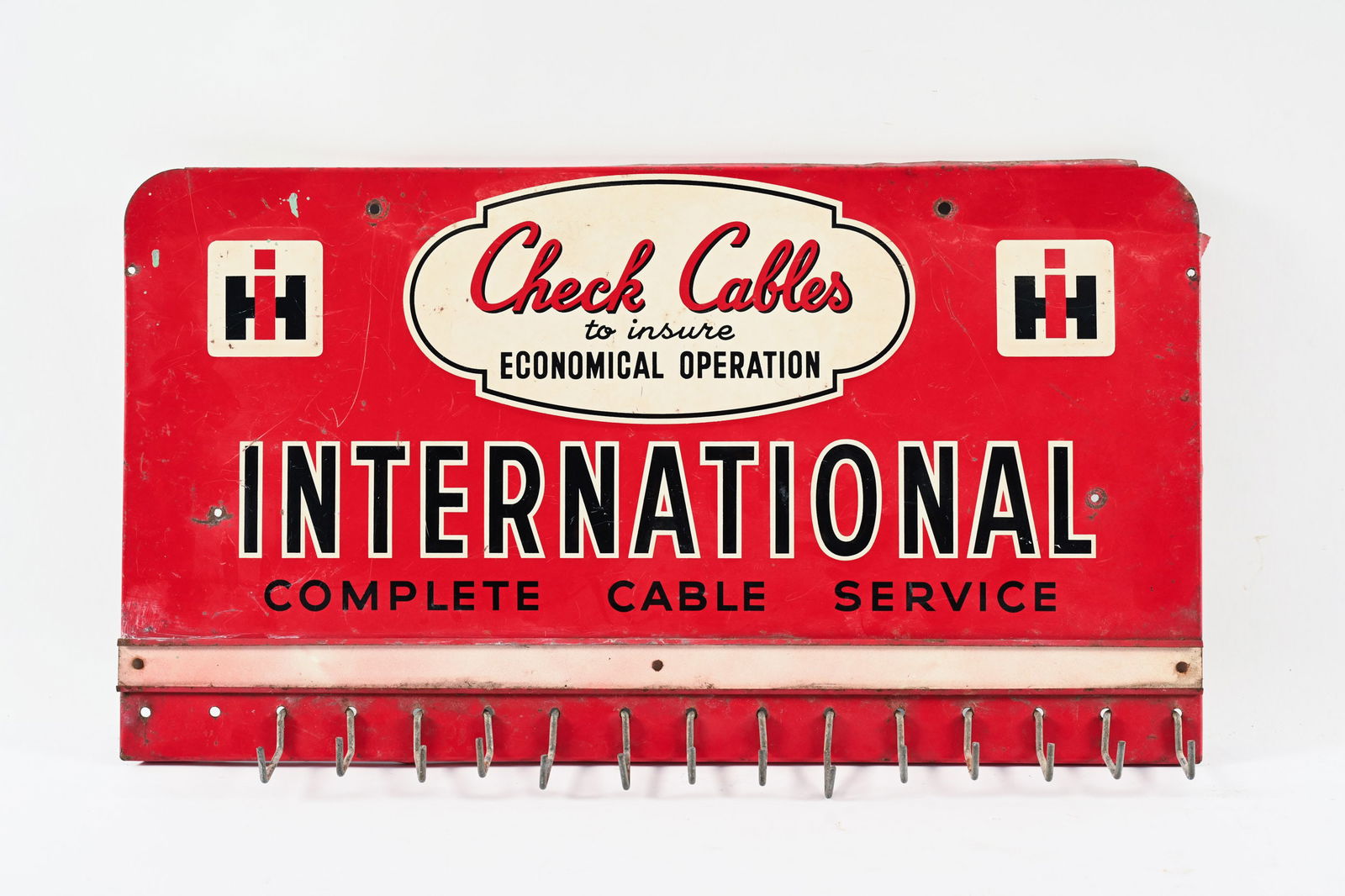 INTL. COMPLETE CABLE SERVICE EMB. TIN RACK SIGN: INTERNATIONAL COMPLETE CABLE SERVICE EMBOSSED TIN RACK SIGN CHECK CABLES TO INSURE ECONOMICAL OPERATION NOT MARKED DISPLAYS WELL WITH GOOD COLOURS FIELD SHOWS SOME WEAR WITH PAINT LOSS TWO EXTRA
