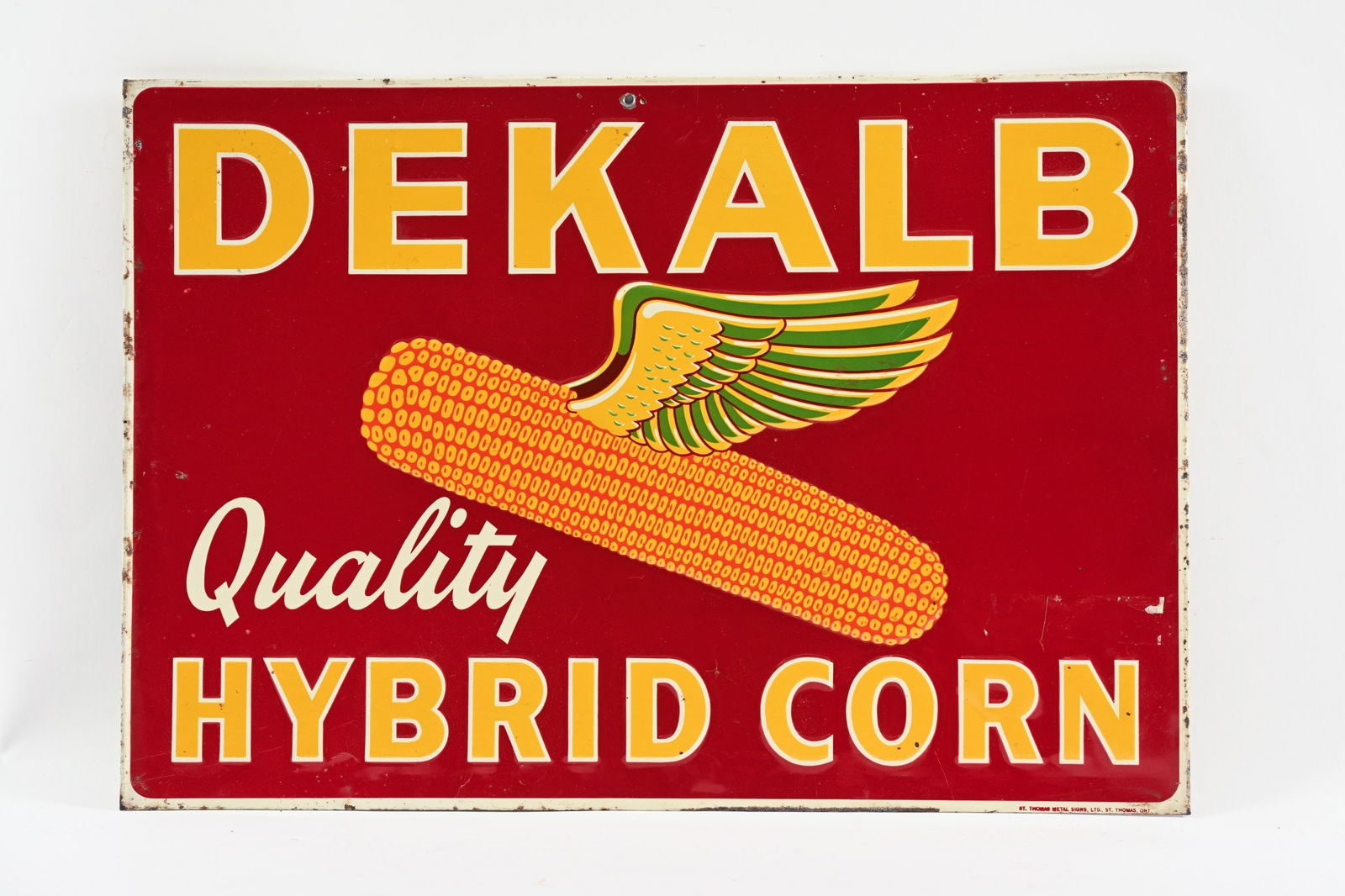 DEKALB QUALITY HYBRID CORN EMBOSSED TIN SIGN: DEKALB QUALITY HYBRID CORN EMBOSSED TIN SIGN MARKED ST. THOMAS METAL SIGNS, LTD, ST. THOMAS, ONT FIELD IN OVERALL GOOD CONDITION SHOWS SOME EDGE WEAR AND MINOR CREASES SLIGHT RICE PAPER RESIDUE IN FIE