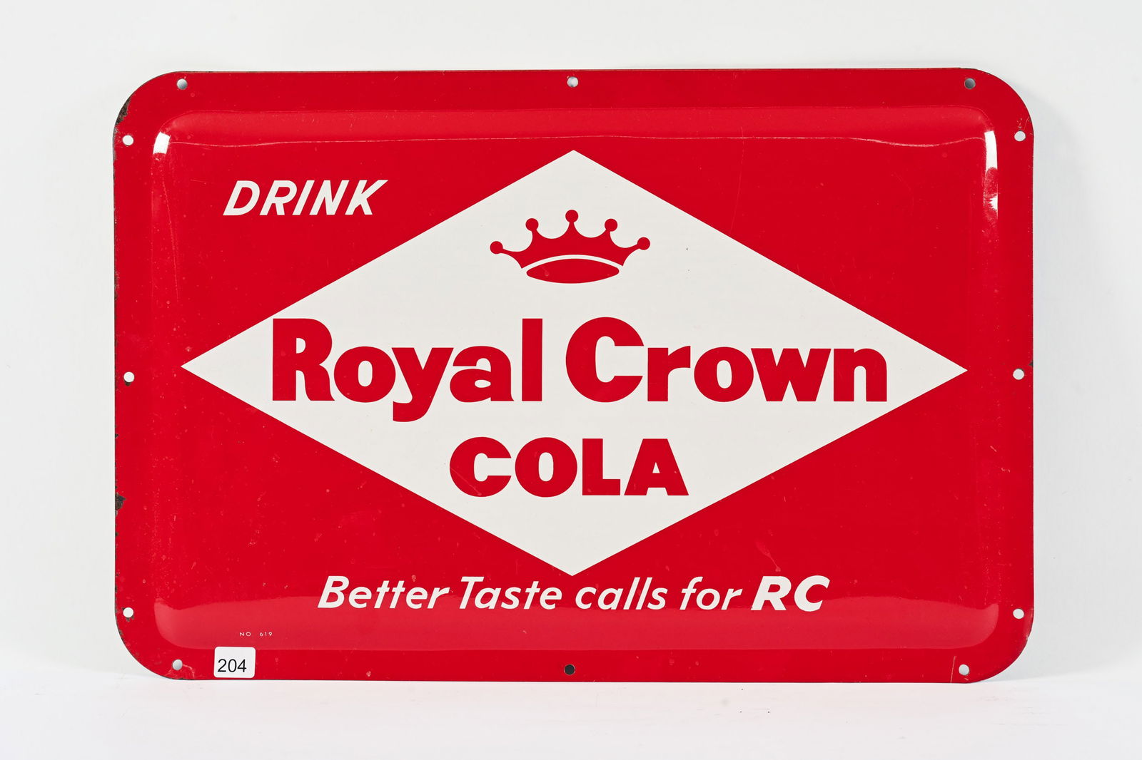 DRINK ROYAL CROWN COLA CONVEX TIN SIGN: DRINK ROYAL CROWN COLA "BETTER TASTE CALLS FOR RC" CONVEX TIN SIGN MARKED NO. 619 NEW OLD STOCK CONDITION SHOWS SOME EDGE WEAR WITH PAINT LOSS AT LEFT SIDE 22.5"X15" *ALL ITEMS GUARANTEED