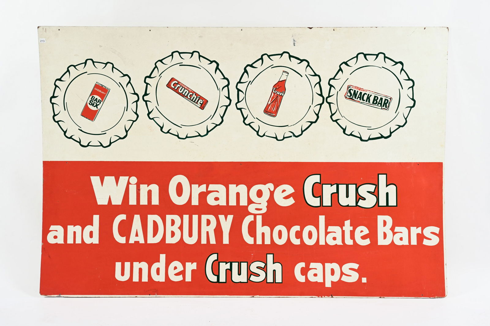 1950'S ORANGE CRUSH & CADBURY MASONITE SIGN: 1950'S ORANGE CRUSH AND CADBURY CHOCOLATES MASONITE PROMOTIONAL SIGN WIN ORANGE CRUSH AND CADBURY CHOCOLATE BARS UNDER CRUSH CAPS NOT MARKED OVERALL GOOD CONDITION WITH STRONG COLOURS SOME SURFACE