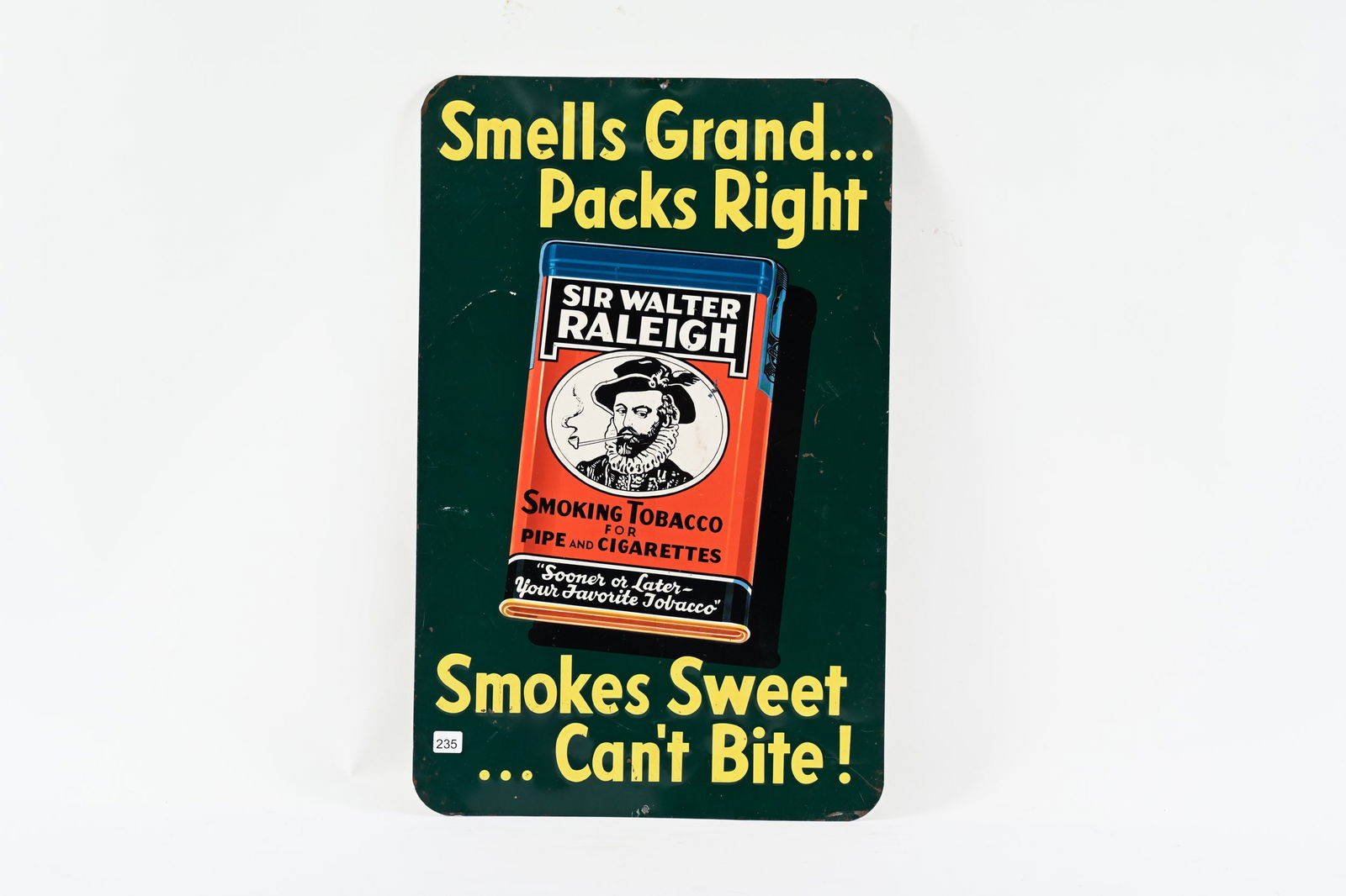 SIR WALTER RALEIGH SMOKES EMB0SSED TIN SIGN: SIR WALTER RALEIGH SMOKES SWEET...CAN'T BITE! EMBOSSED TIN SIGN MARKED J.V. REED & CO. LOUISVILLE, KY, LITHO IN U.S.A. GOOD COLOURS AND GLOSS SHOWS SOME WEAR WITH PAINT LOSS AT EDGES AND MINOR