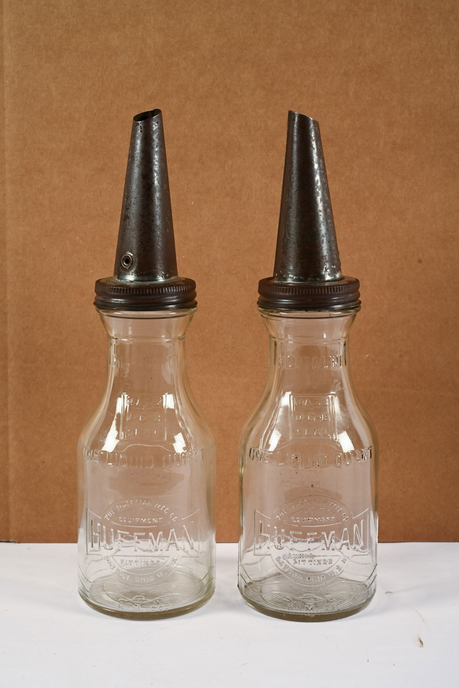 PAIR OF HUFFMAN GLASS QT MOTOR OIL BOTTLES W/SPOUTS: PAIR OF HUFFMAN GLASS QUART MOTOR OIL BOTTLES WITH SPOUTS HUFFMAN MFG, CO. DAYTON, OHIO EMBOSSED GLASS NO CHIPS OR CRACKS