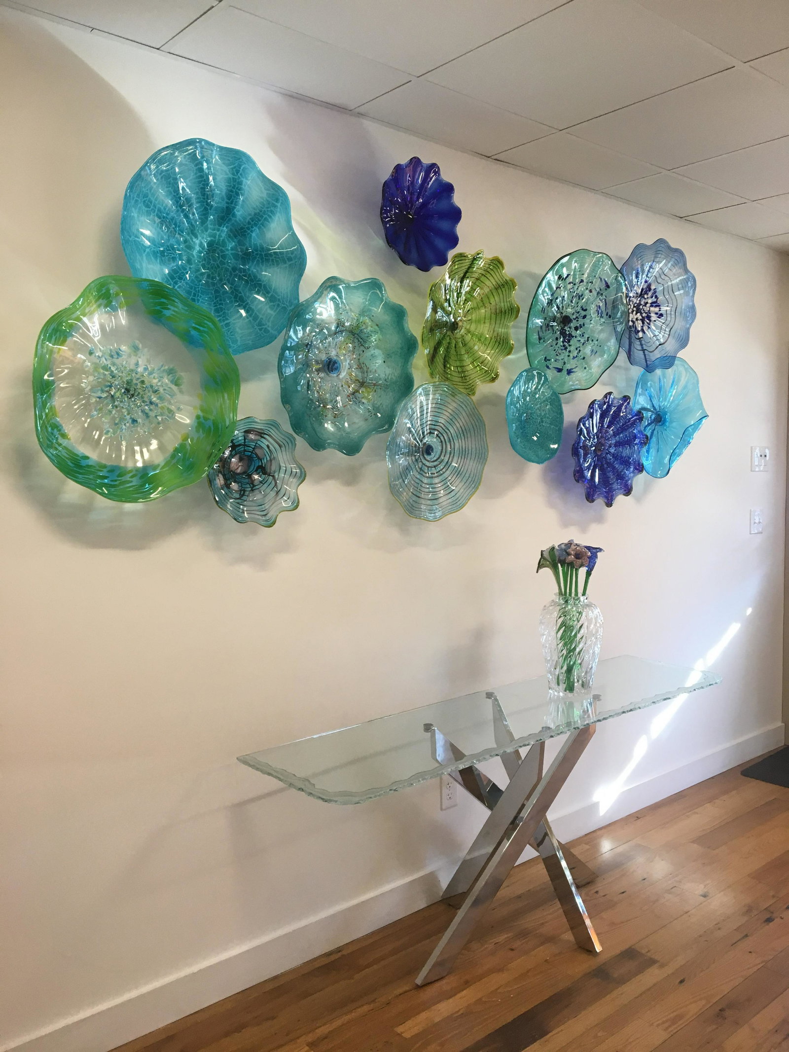 Carved glass console table: 28 x 72 x 18 carved glass top console table. Chrome legs in modern design. Glass is UV bonded to chrome female buttons to keep glass secure at all times. Easily comes apart for moving. Top made by art