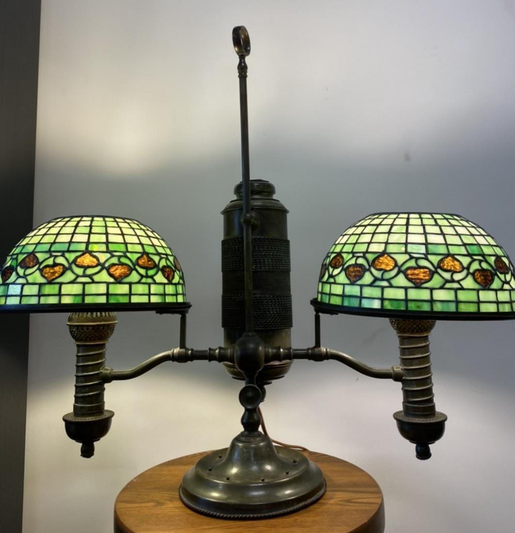 Marked \"Tiffany Studios New York\" student lamp: For your consideration is a student lamp with two acorn shades, both marked to the interior rim \"Tiffany Studios New York\". The lamp base itself is believed to be from the Manhattan Brass Company. T
