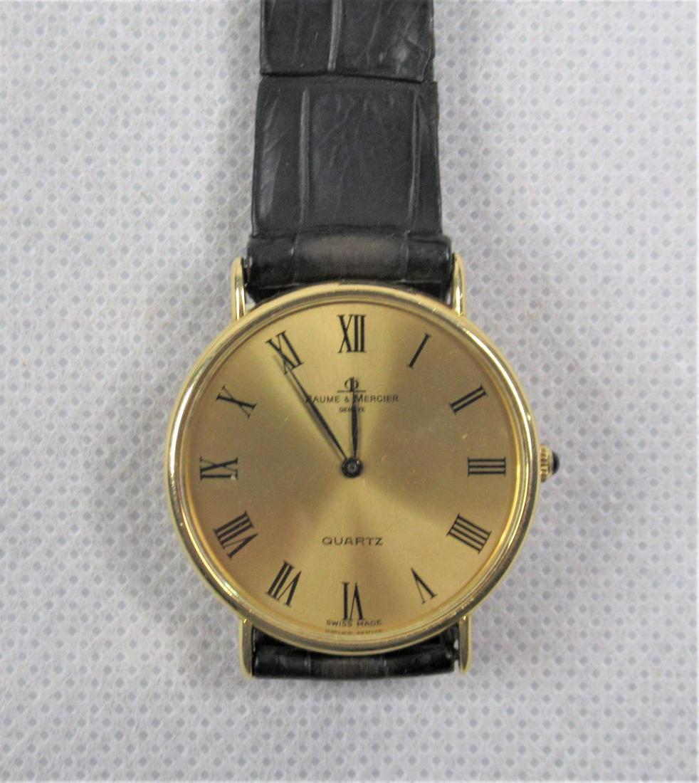 An 18ct Gold Baum & Mercier Gents' Wristwatch: BM10025 Quartz movement in working order. Hallmarked 18ct Yellow Gold Baum & Mercier case approx. 33mm and set with cabochon blue stone to crown. Matching gold plated buckle/clasp, with box and papers