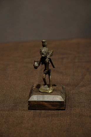 Ashanti goldweight man holding some wood and two pots