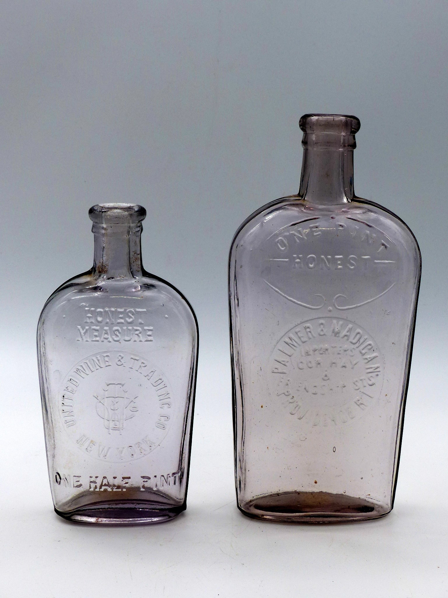 Group Of 2 Honest Measure Antique Flask: Group of 2 Honest Measure Antique Flask -Palmer & Madigan 1 pt. Providence R.I (8 1/8"); United Wine & Trading Co. 1/2 Pt. New York (7 1/4") ; Condition: Mint ;