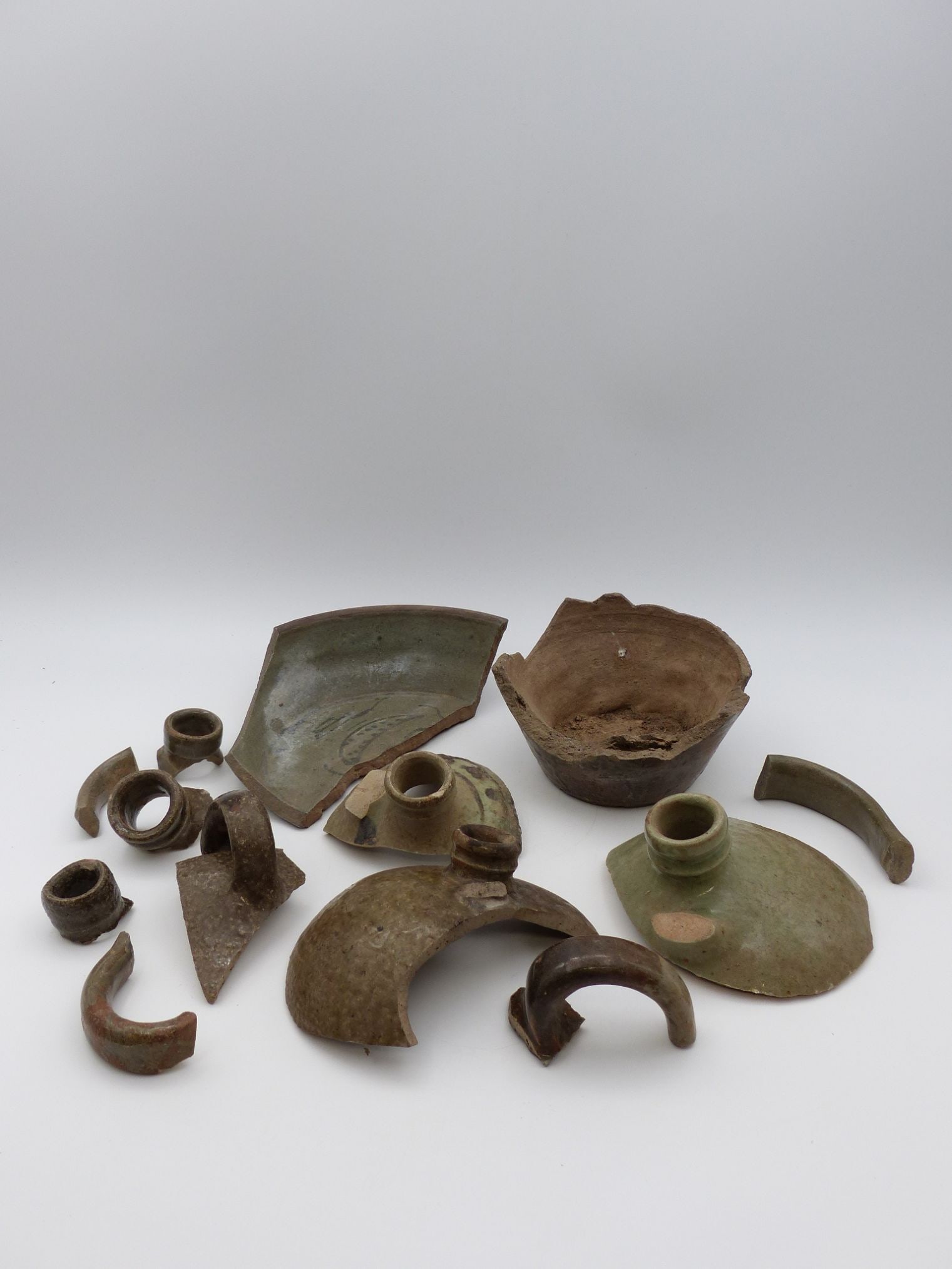 Trap & Chandler Pottery Shards Collection: This exquisite collection of Trap & Chandler pottery shards showcases a diverse array of antique artifacts, indicative of both technical craftsmanship and aesthetic value. The shards exhibit a rich ta