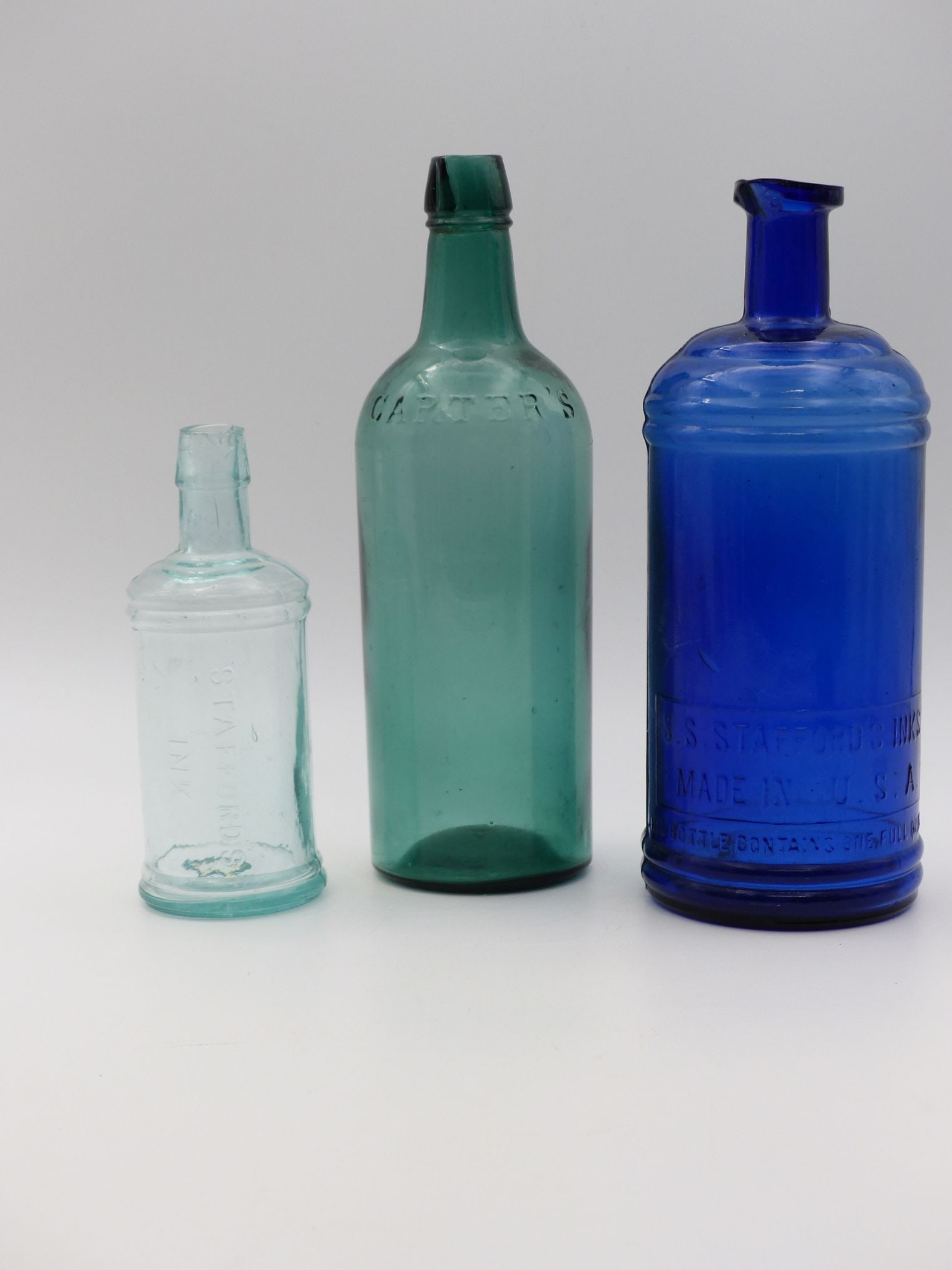 Stafford & Carter's Inc. Bottle Collection: This remarkable collection features three distinct glass bottles from Stafford & Carter's Inc., showcasing a blend of vintage aesthetic and historical significance. The leftmost bottle, engraved with 