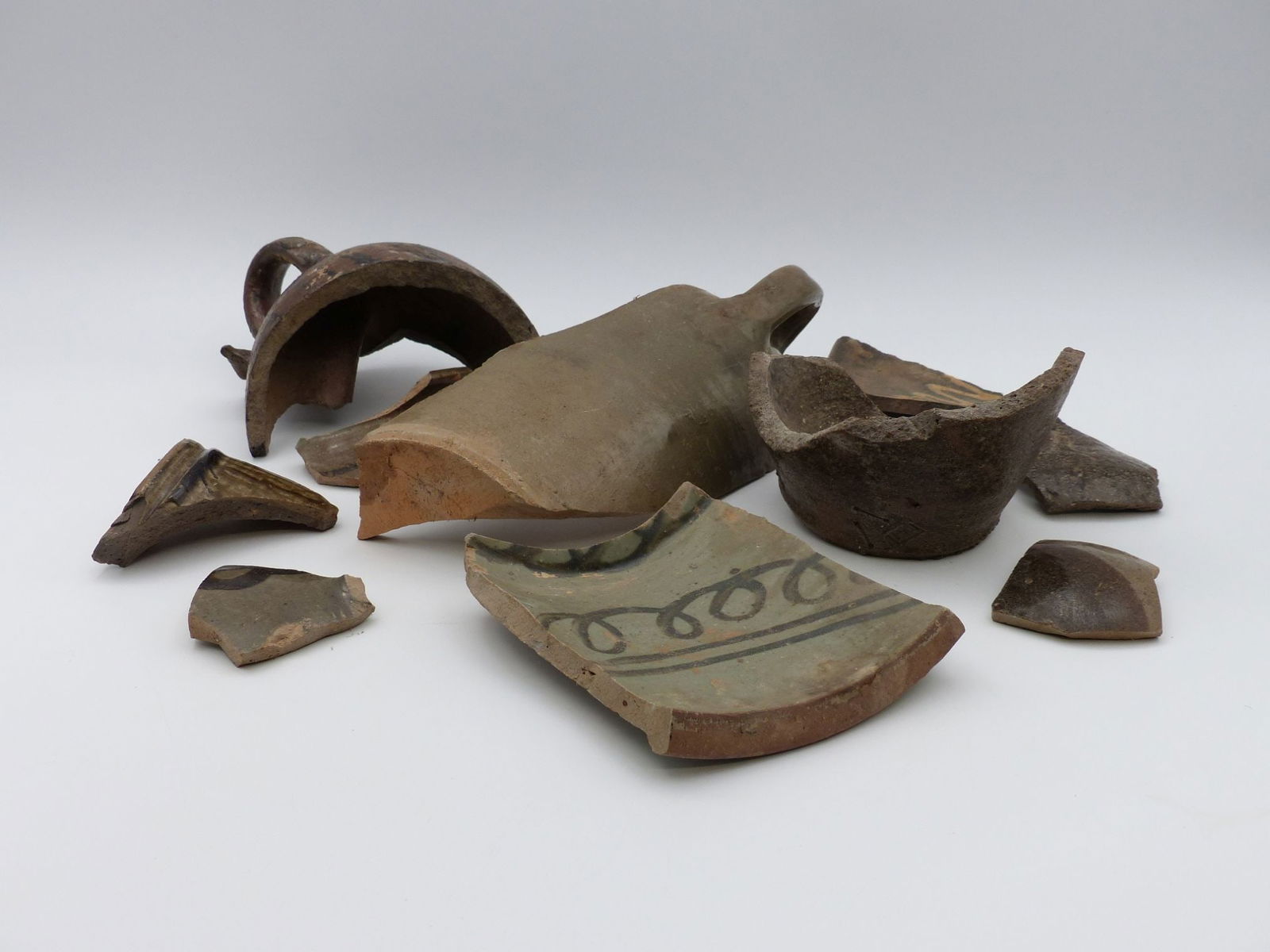 Trap & Chandler Pottery Shards Collection: This striking collection of Trap & Chandler pottery shards showcases a diverse array of fragments, including bowls and jugs, characterized by meticulous craftsmanship and unusual decorative elements.