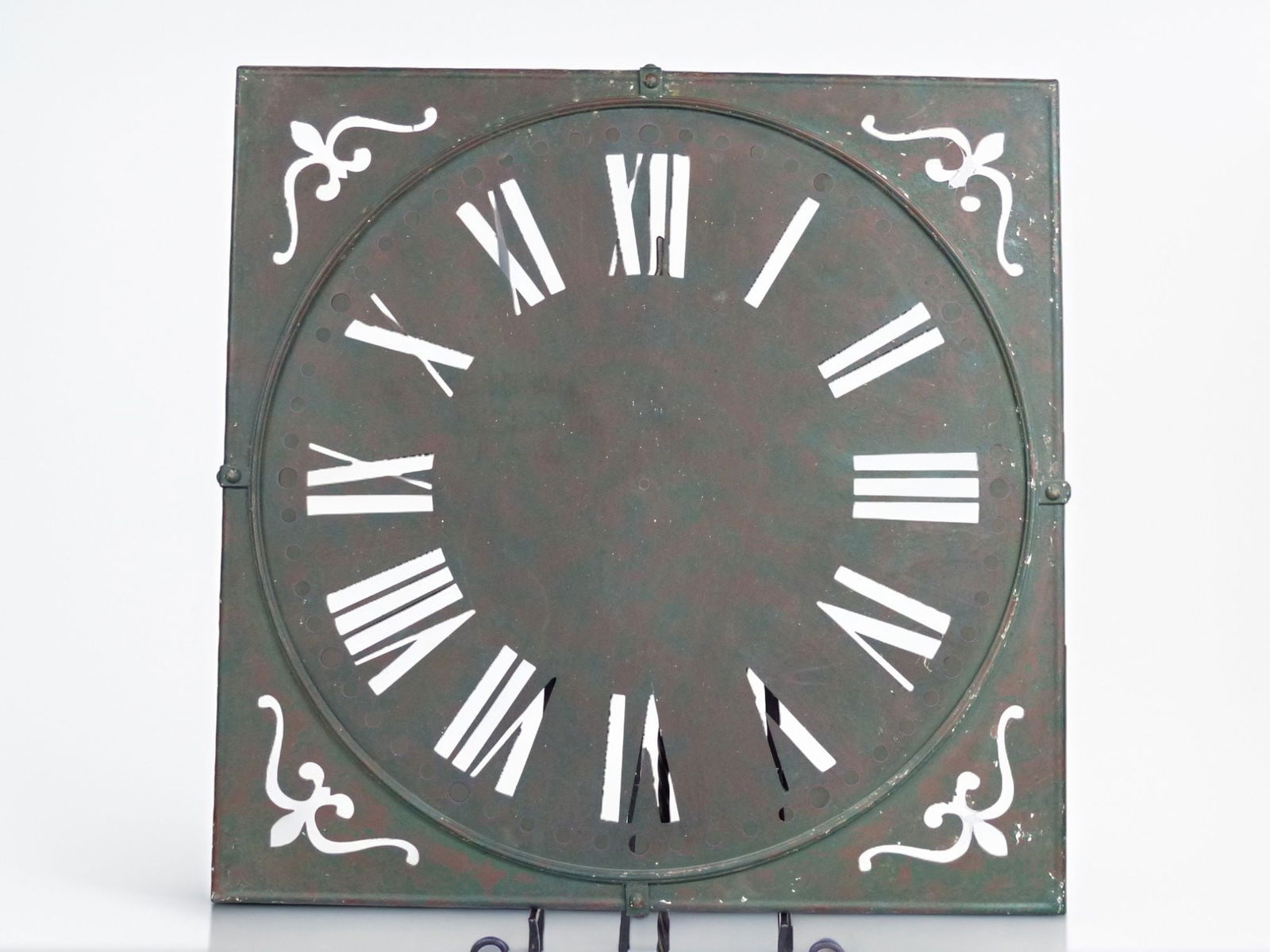 Large Metal Clock Face with Roman Numerals: This striking large metal clock face features classical Roman numerals, showcasing a timeless design that would enhance both traditional and contemporary decor. The aged patina on the surface adds a v