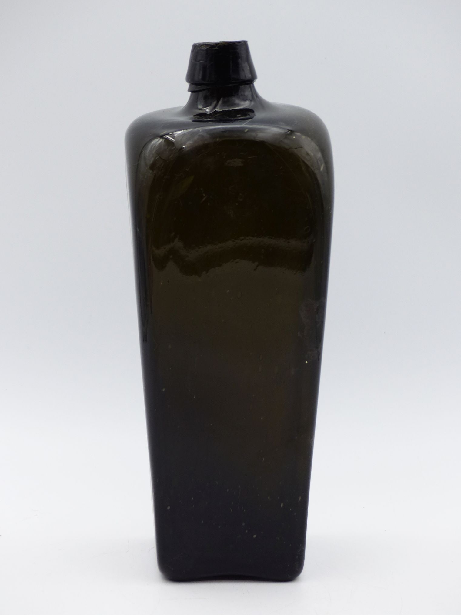 Dark Green Gin Bottle (Excellent Condition): This exquisite dark green gin bottle, characterized by its elegant silhouette and sturdy construction, epitomizes vintage craftsmanship. Its glossy surface reflects light beautifully, showcasing subtl