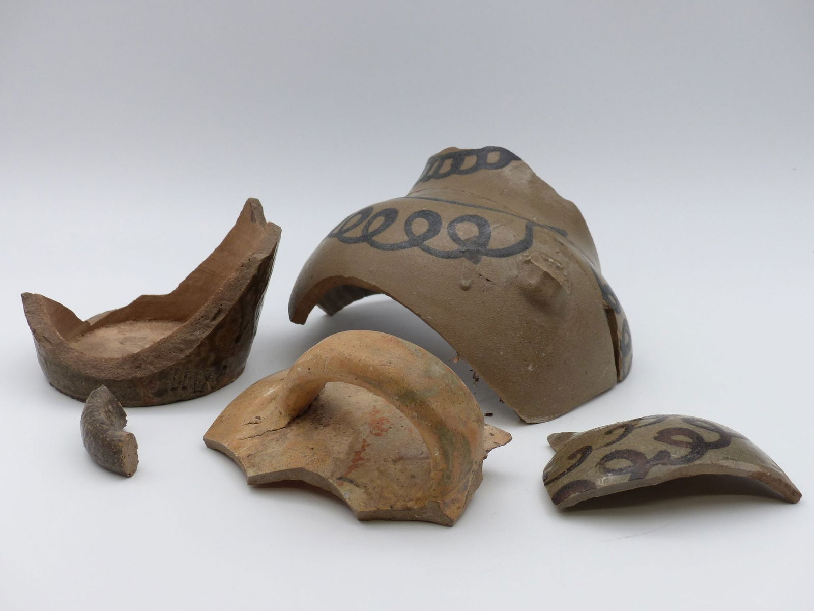 Trap & Chandler Shards with Rare Roman Numeral Marks: This lot features a unique assemblage of Trap & Chandler shards, showcasing rare Roman numeral marks indicative of its historical significance. The collection includes several ceramic fragments with i