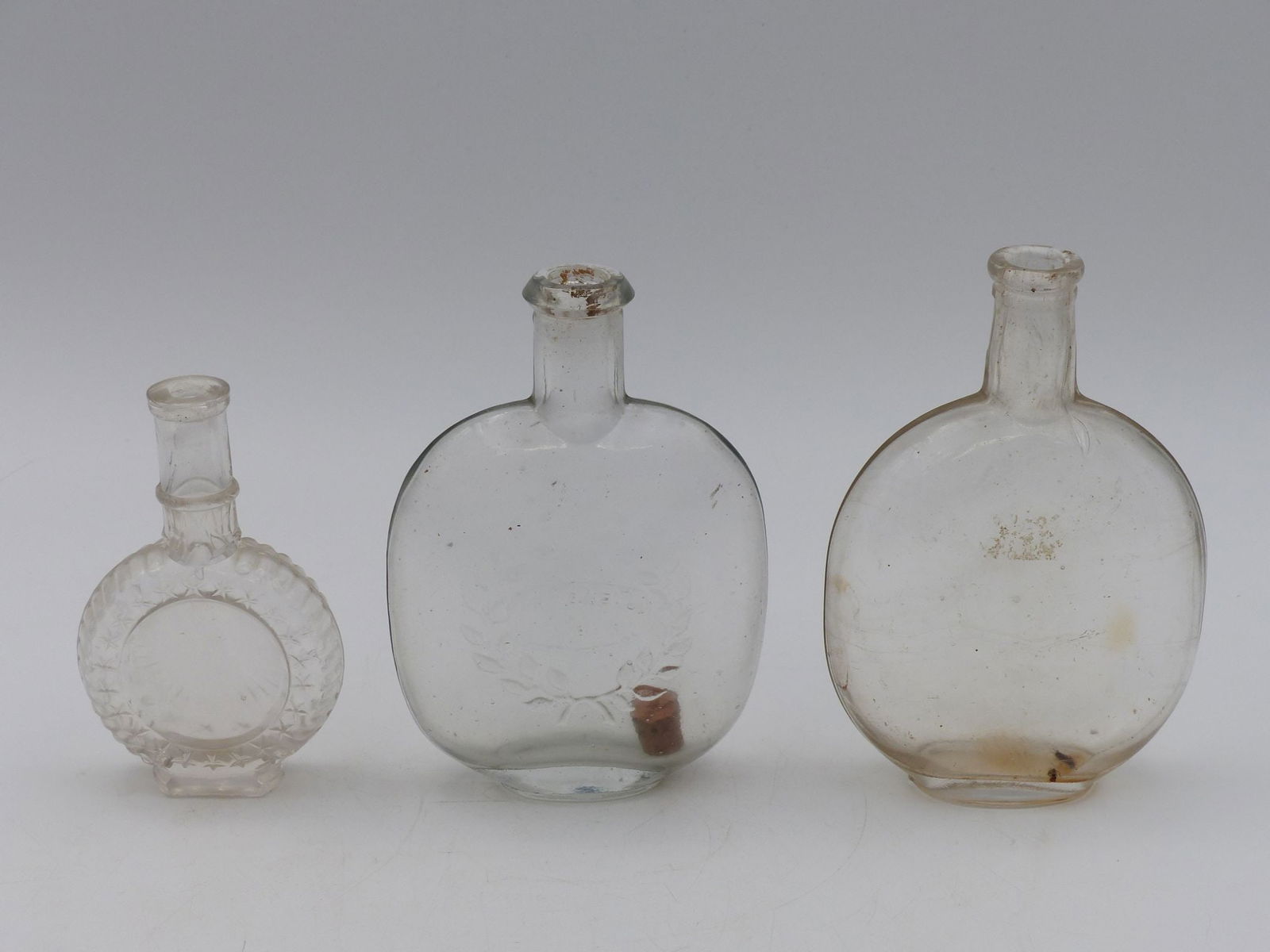 Clear Pumpkin Seed Flask Collection: This exquisite set of Clear Pumpkin Seed Flasks showcases three distinct vessels, each exhibiting unique craftsmanship and clarity of glass. The flasks are characterized by their elegant pumpkin seed