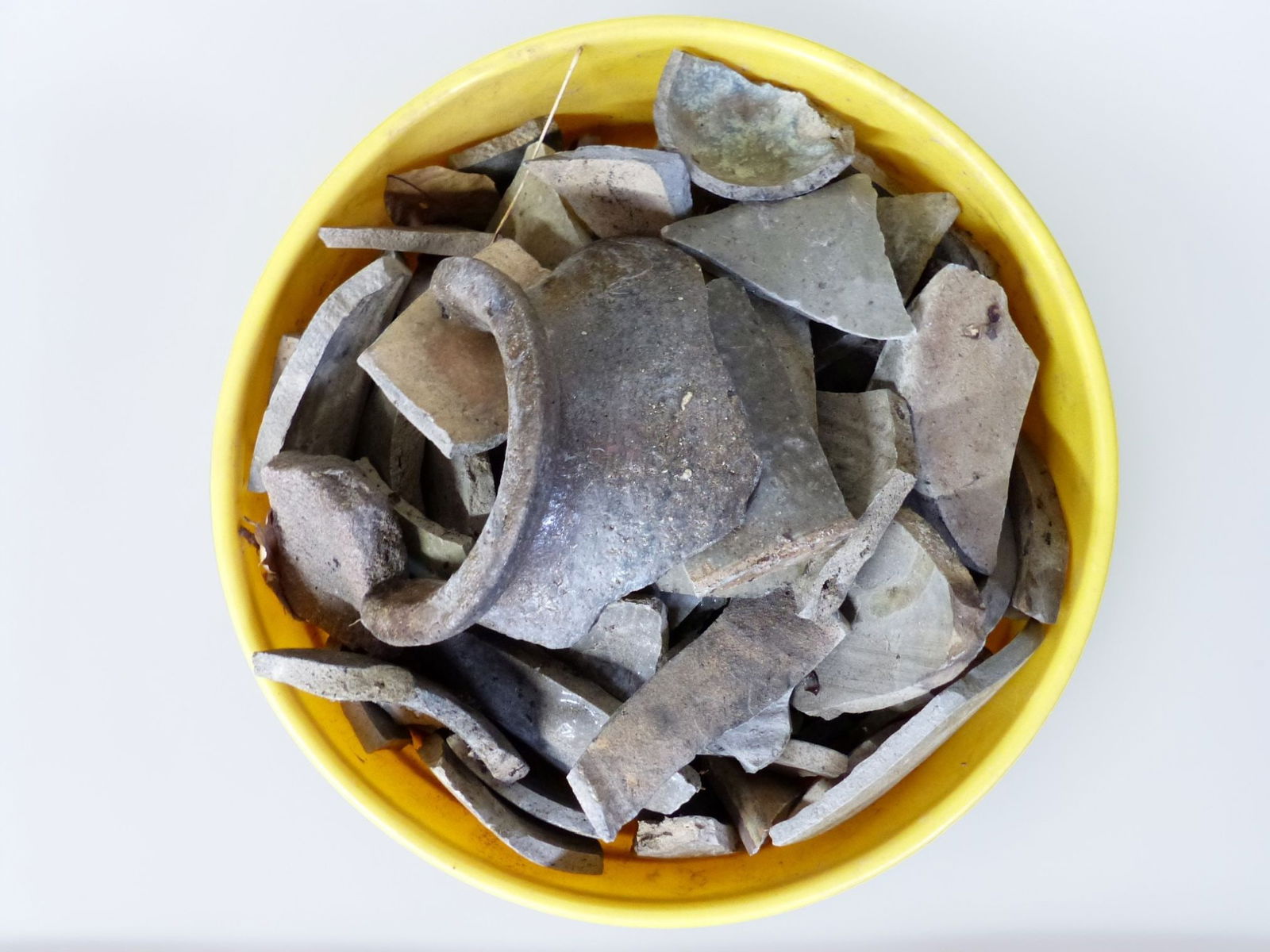 Trap & Chandler 5-Gallon Shard Bucket: This striking 5-gallon shard bucket features an intriguing assortment of historical ceramic fragments, showcasing the craftsmanship and materials of its era. Housed within a vibrant yellow bucket, the