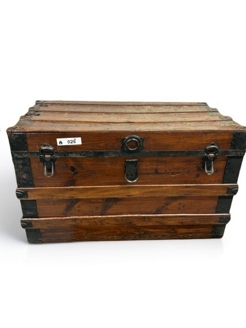 Antique Wooden Steamer Trunk with Metal Bindings: This classic antique steamer trunk features a sturdy wooden construction reinforced with dark metal bands and protective corner brackets. The exterior displays a rich, warm wood grain finish, characte