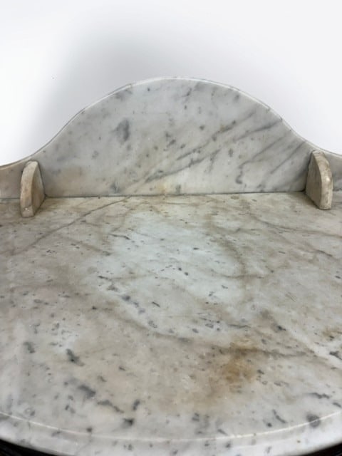 Victorian Mahogany Marble-Top Console Table: This elegant mid-19th century console table features a semi-circular white marble top with a shaped backsplash, resting on a mahogany veneered frame. The base is supported by a central acanthus-carved