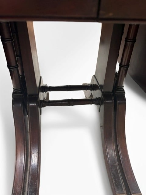 Regency Style Mahogany Pembroke Table: This elegant Regency style Pembroke table is crafted from rich mahogany, featuring a rectangular top with two drop leaves that expand for added versatility. The piece is supported by two distinctive