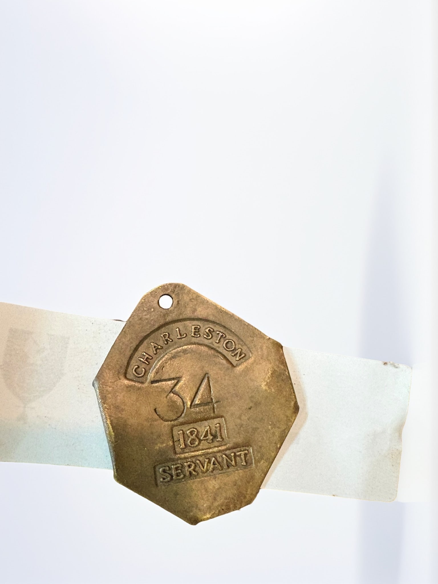Purported 1841 Charleston Servant Badge: This is a rare and historically significant brass badge from Charleston, South Carolina, dated 1841. These badges were historically required to be worn by enslaved or free people of color in Charlesto