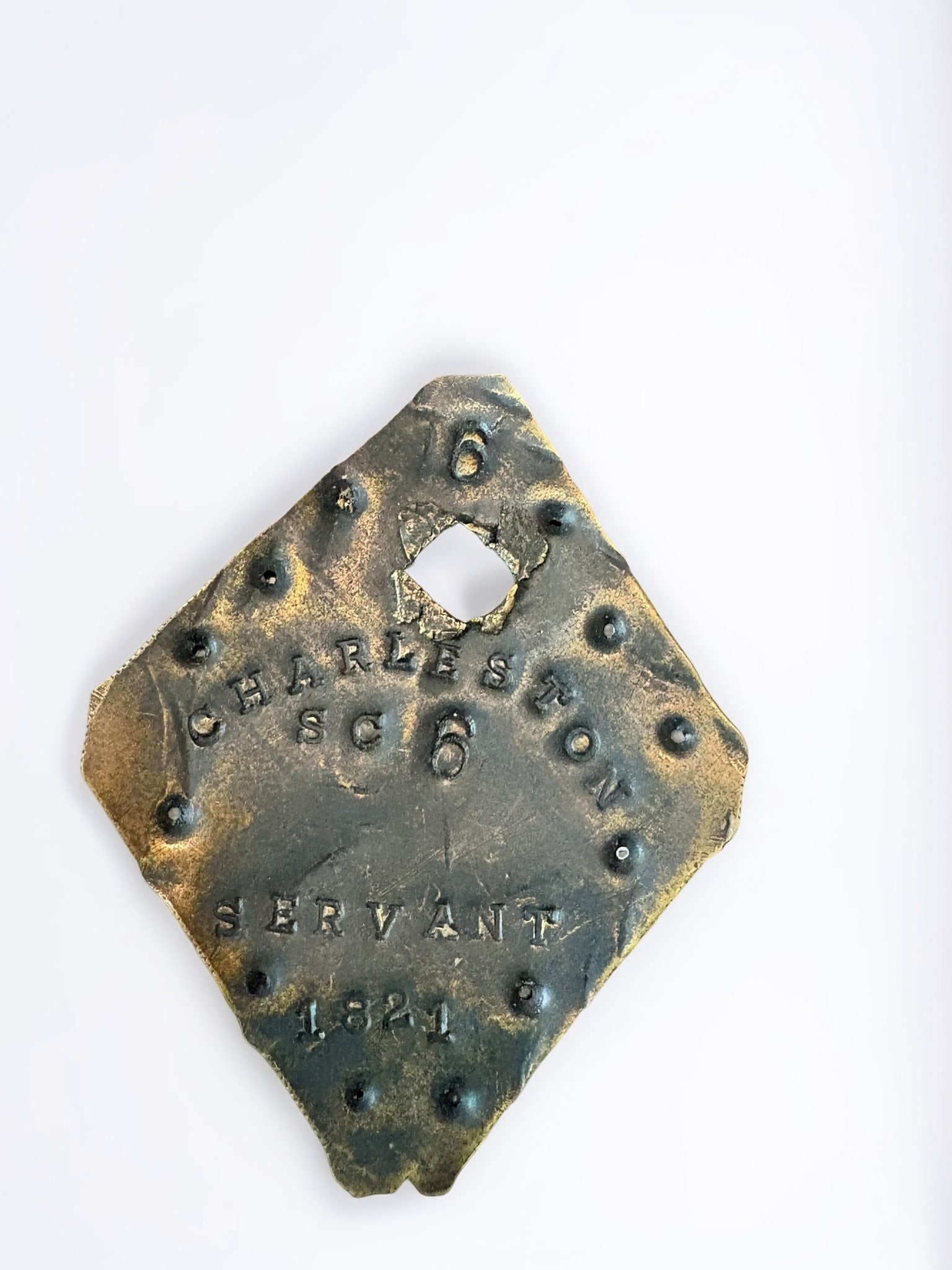 Purported 1821 Charleston South Carolina Brass Slave Tag: This is an authentic 1821 brass 'Servant' badge issued by the City of Charleston, South Carolina. These tags were mandated by municipal law and required to be worn by enslaved people who were hired ou
