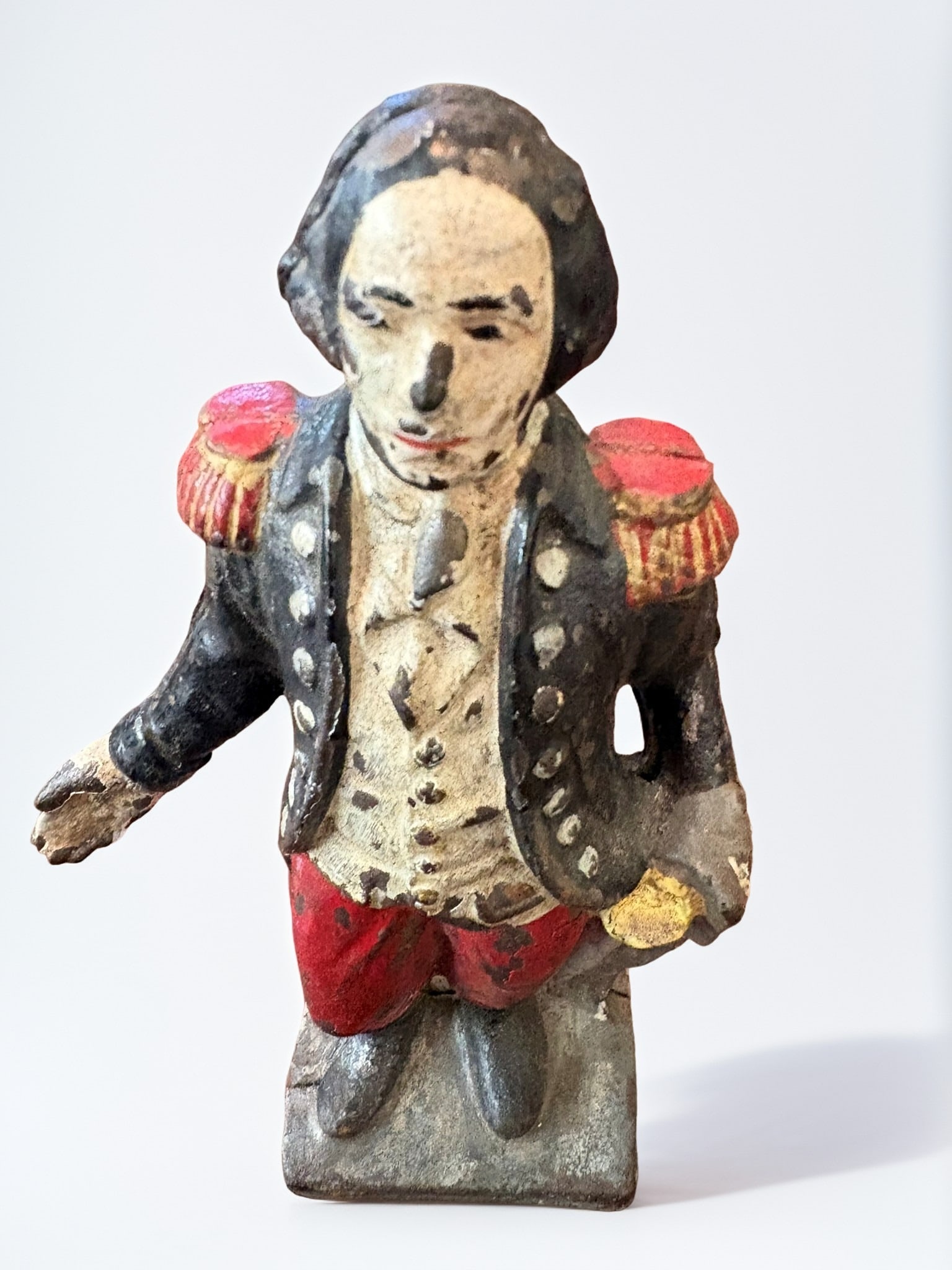 Cast Iron Mechanical Still Bank of a Napoleonic Figure: This antique cast iron mechanical still bank depicts an officer in a formal 19th-century military uniform, reminiscent of Napoleonic styles. Featuring original polychrome paint, the figure is rendered