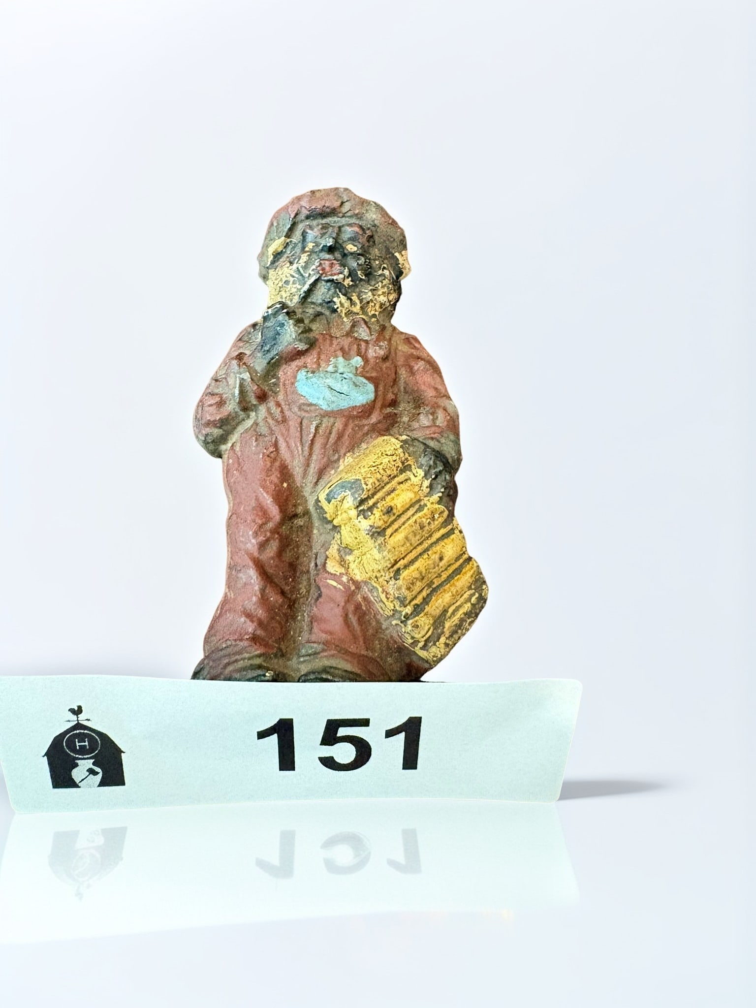 RARE Vintage Cast Iron One-Sided Santa Figure: A charming and rare vintage one-sided cast iron figure of a Santa Claus character, depicted wearing a hat and overalls while carrying a gold-painted bag or present. The piece features original hand-pa