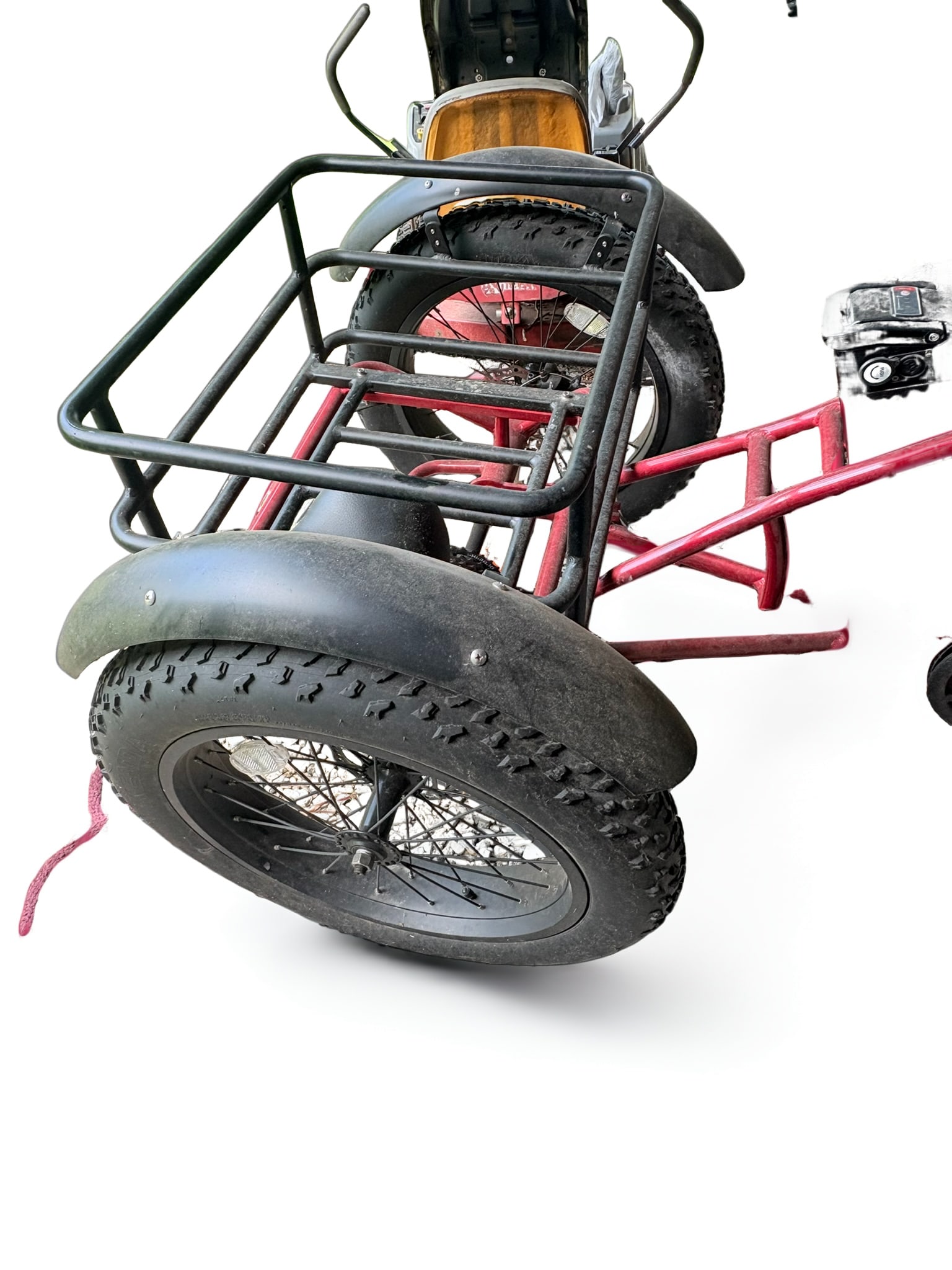 CozyTrikes Electric Fat Tire Cargo Tricycle - E-Trike: This CozyTrikes electric cargo tricycle features a robust red steel frame, fat tires suitable for various terrains, and a rear cargo rack for utility. The unit is equipped with a battery pack and peda
