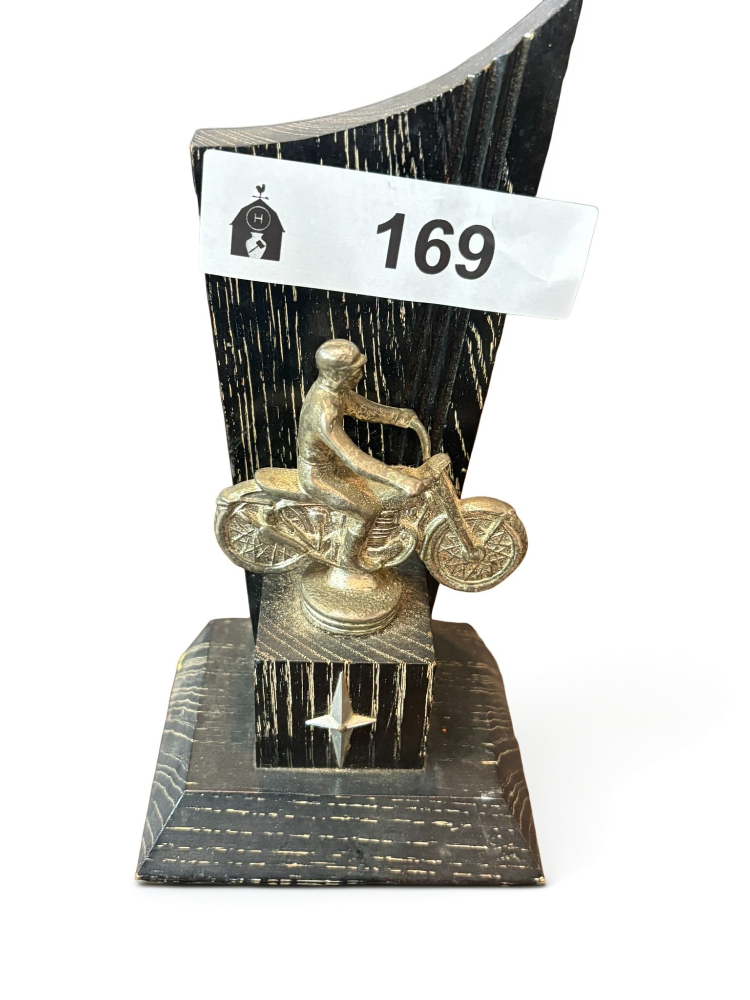 Vintage Motorcycle Racing Trophy: This vintage trophy features a detailed, silver-toned figurine of a motorcycle racer mounted atop a striking, dark-stained wooden base with decorative geometric accents. The piece captures the spirit 