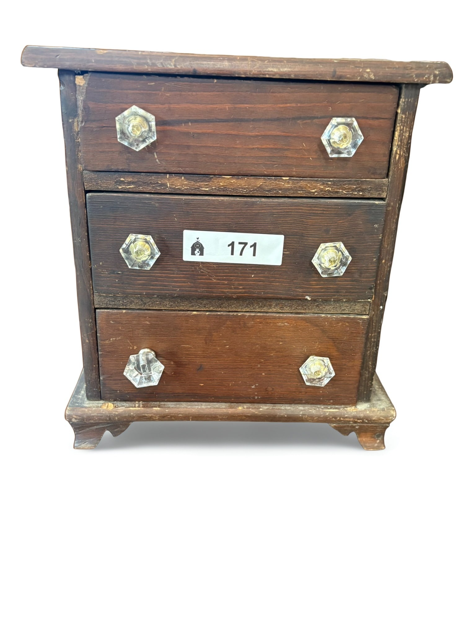 Small Antique Three-Drawer Wooden Miniature Chest: This is a charming, small-scale wooden chest featuring three horizontal drawers, each adorned with distinctive hexagonal glass knobs. The piece exhibits a dark, aged finish on the wood, consistent wit