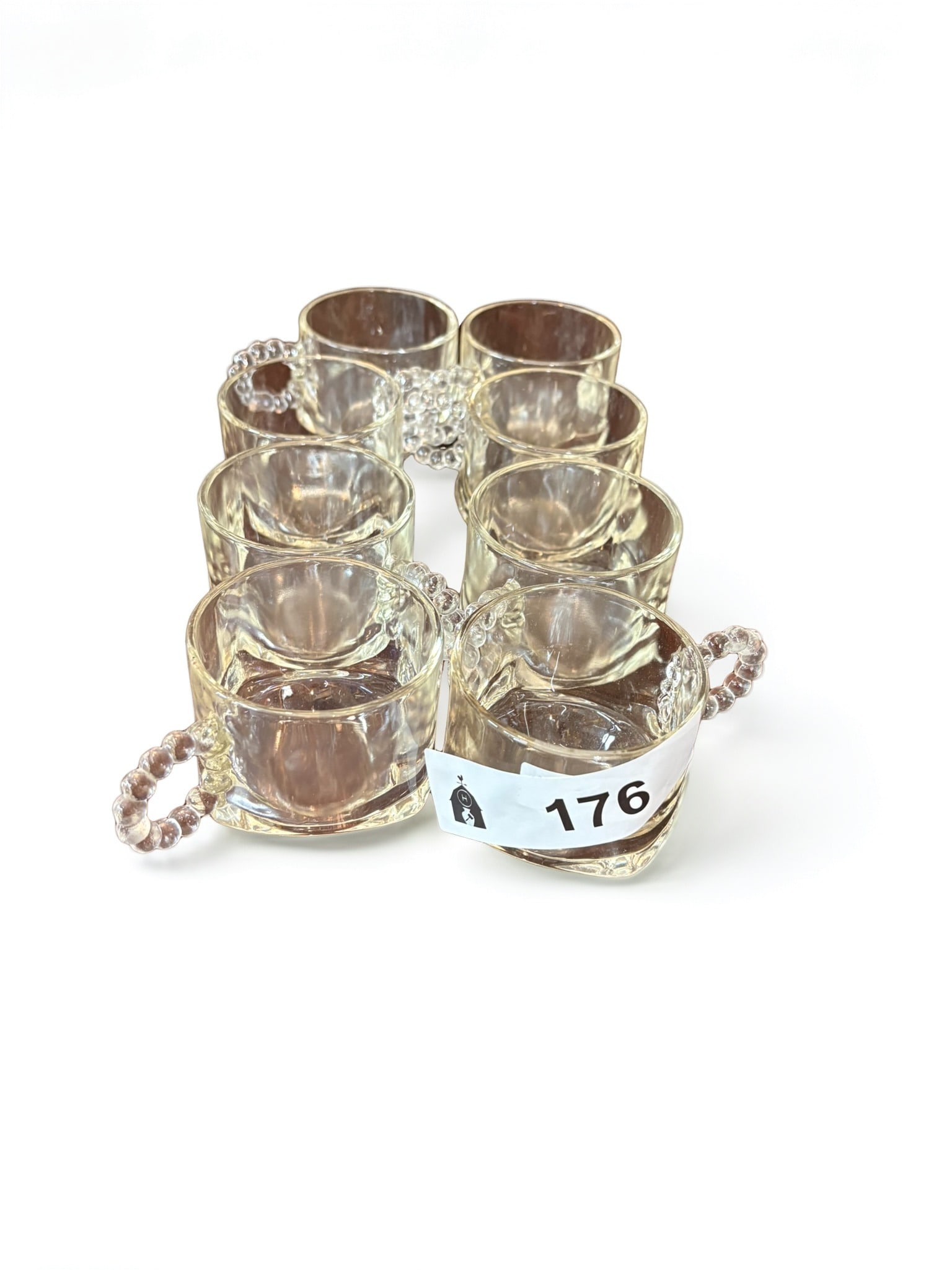 Set of Vintage Pressed Clear Glass Punch Cups with Beaded Handles: This set of vintage clear glass punch cups features a classic design enhanced by decorative beaded handles. Each cup is crafted from durable pressed glass, offering a timeless aesthetic suitable for e