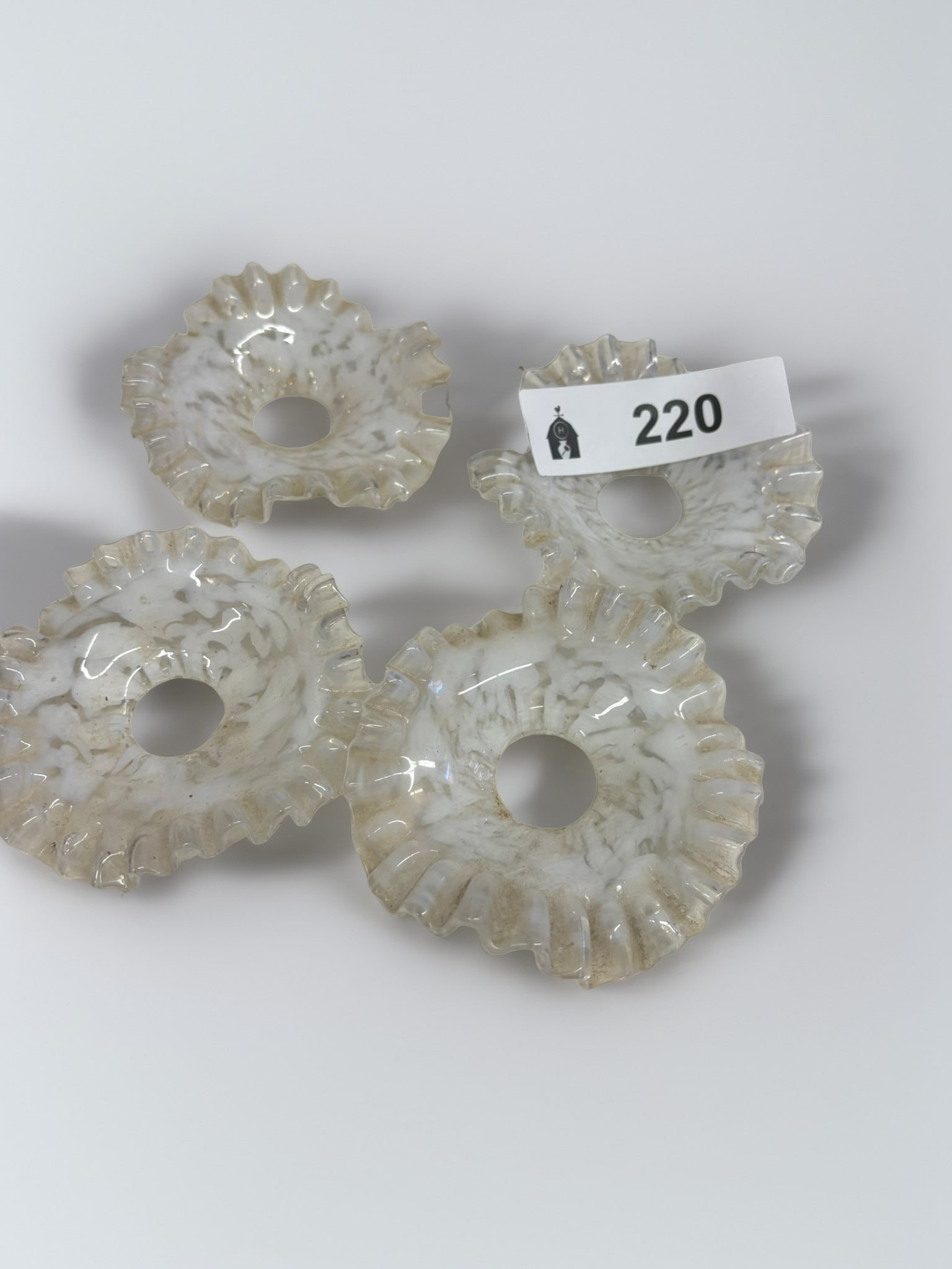 Set of Four Victorian-Style Ruffled Glass Lamp Shades: This collection features four elegant Victorian-style lamp shades crafted from white art glass with a delicate ruffled edge. These pieces exhibit a characteristic marbled white finish that creates a s