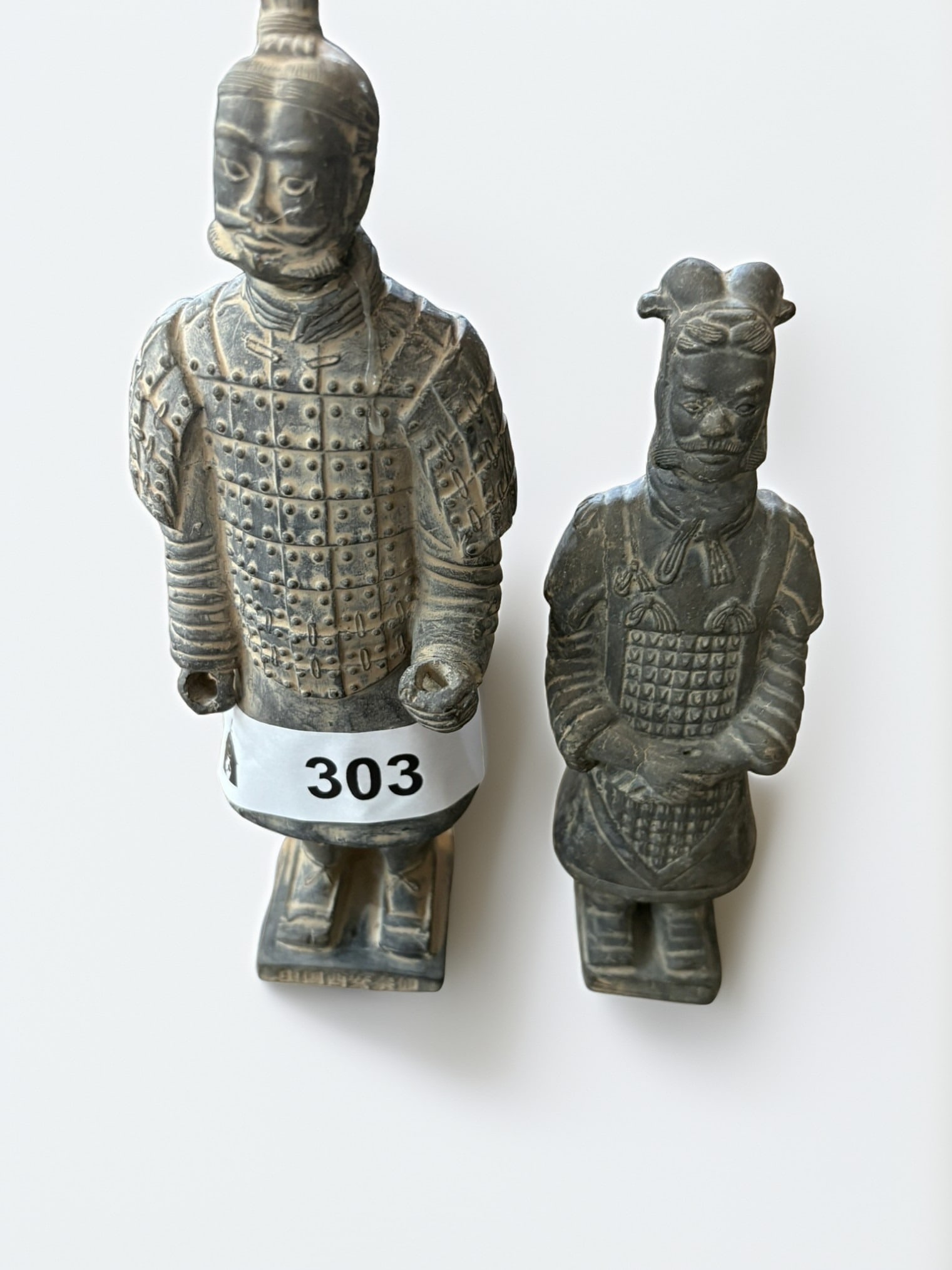 Pair of Terracotta Army Warrior Replicas: This set features two decorative replicas inspired by the iconic Terracotta Army of Emperor Qin Shi Huang. Crafted from a dark gray earthenware material, each figure depicts a soldier in detailed armo