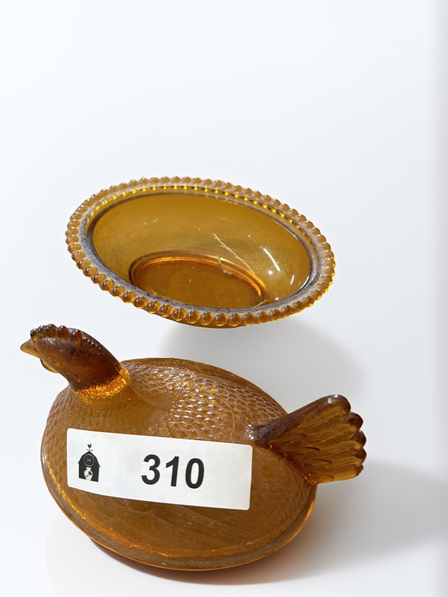 Vintage Amber Glass Hen on Nest Covered Dish: This charming vintage covered dish features a detailed hen resting on a textured, beaded-edge nest. Crafted in rich amber glass, this piece showcases the classic design associated with mid-century Ame