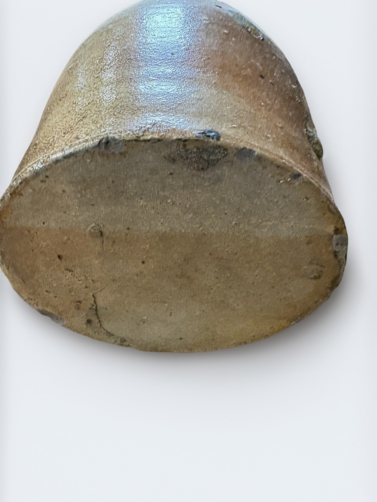Antique American Salt-Glazed Stoneware Crock: This classic American salt-glazed stoneware crock features a robust, cylindrical form with a thick, applied rim. The exterior showcases a characteristic light tan, speckled salt-glaze finish with visi